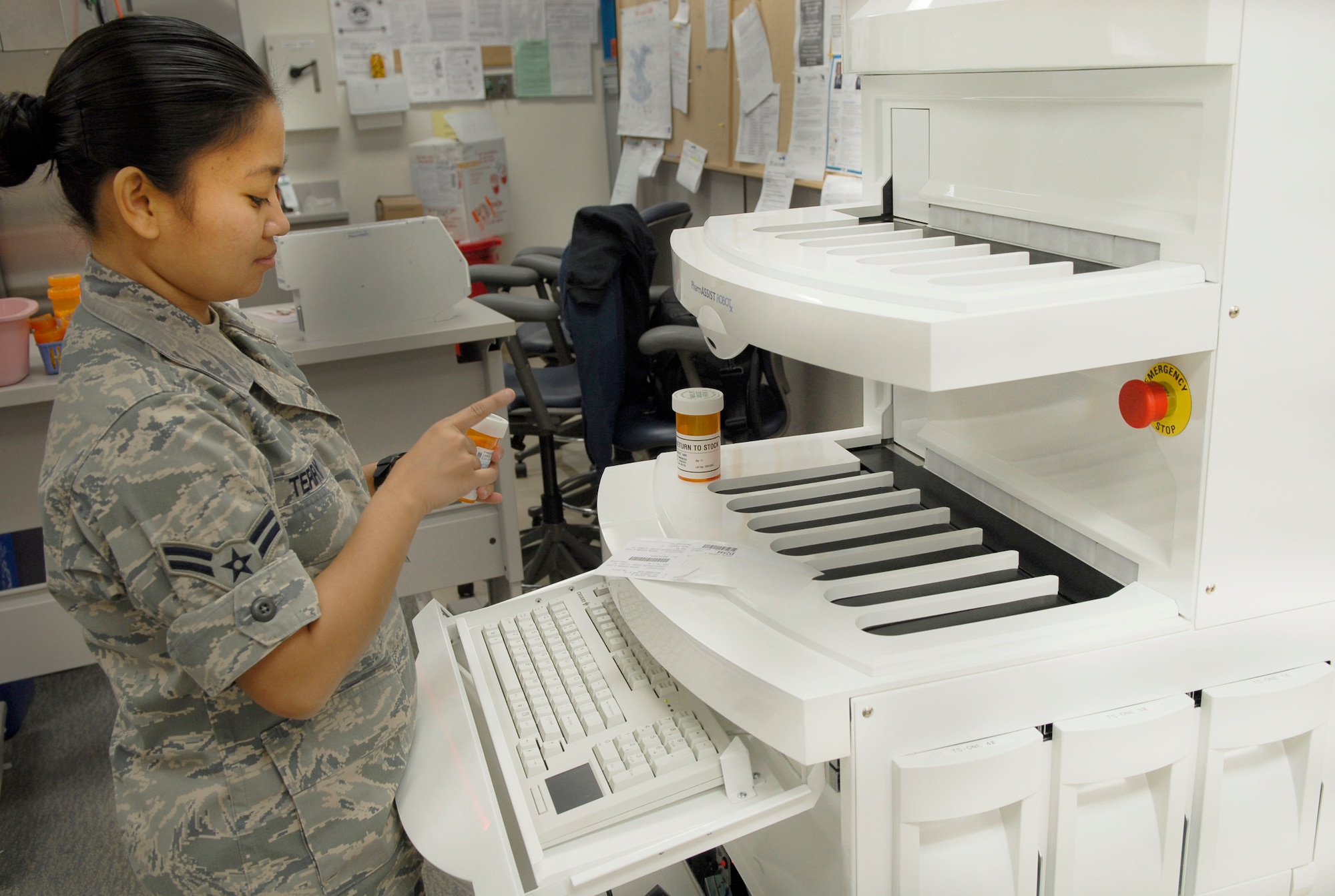Airman 1st Class Roma Terry adds a label to a patient's prescription Dec. 10, 2010, at Kadena Air Base, Japan. The PharmASSIST ROBOTx assures patient safety with bar code scans of all electronically processed prescriptions. Airman Terry is a pharmacy technician with the 18th Medical Support Squadron. (U.S. Air Force photo/Airman 1st Class Tara A. Williamson)