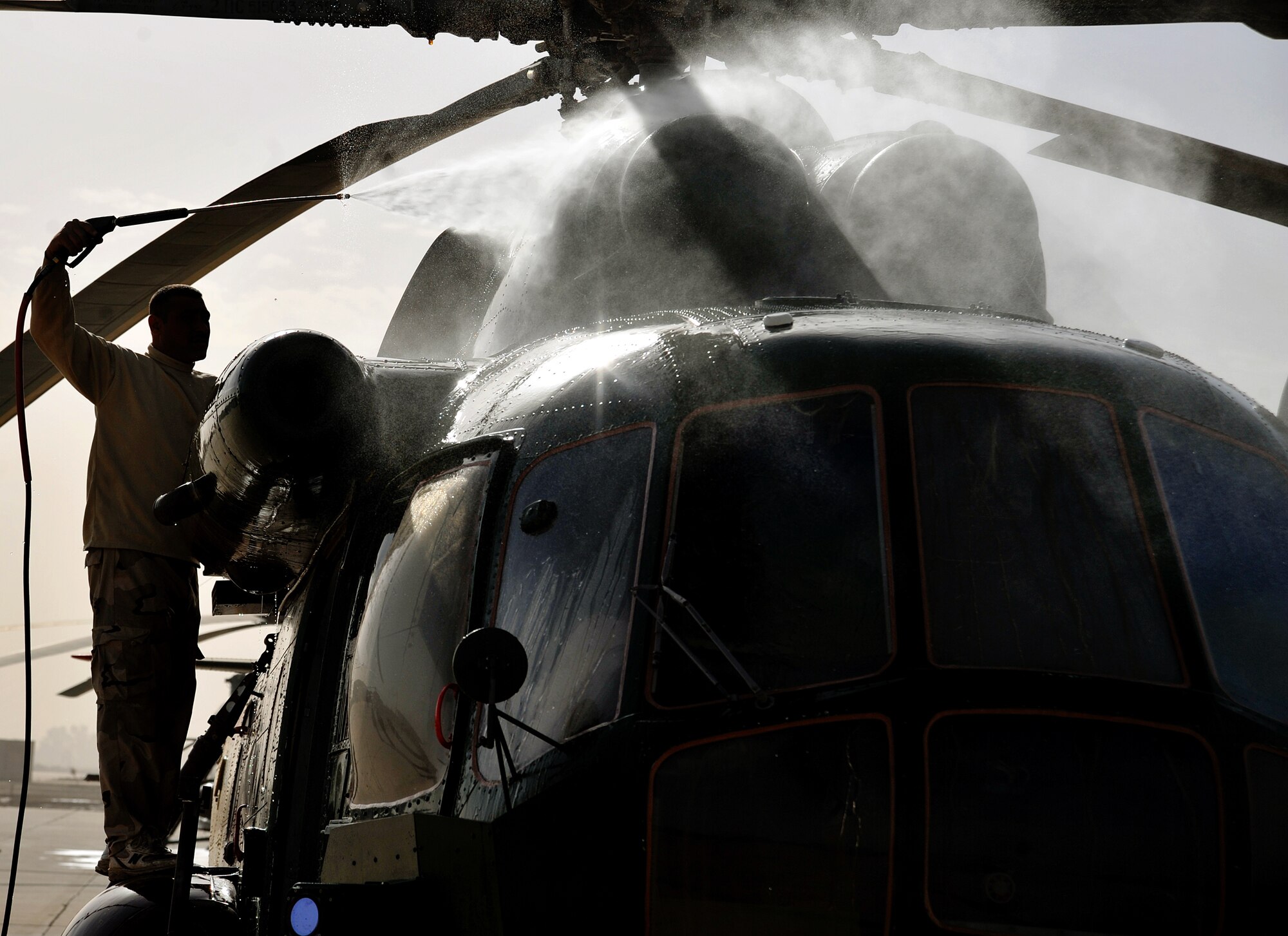 An Iraqi Army Aviation Command soldier power washes the dirt off of a Mi-17 helicopter on the flightline Dec. 11, 2010, in Taji, Iraq. 721st Air Expeditionary Advisory Squadron air advisors work with the AAC at Taji to advise and assist them in building a safe, self-sustaining Iraqi rotary-wing force. (U.S. Air Force photo/Senior Airman Andrew Lee)