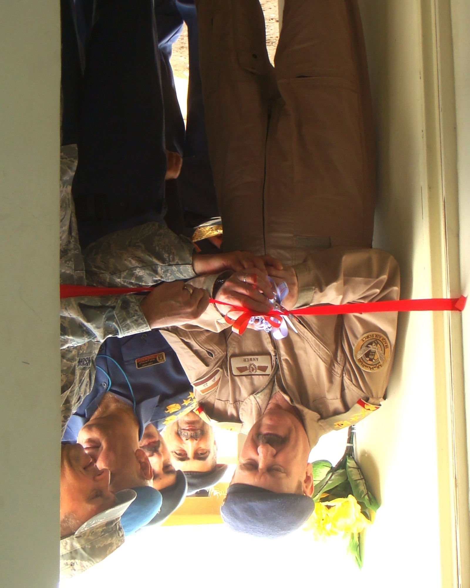 Lt. Gen. Anwar Hamad Amen Ahmed, Iraqi Army Inspector General, and Brig. Gen. Scott Hanson, Iraq Training and Advisory Mission - Air Force, and 321st Air Expeditionary Wing commander, cut the ribbon for the new communications equipment storage building at New Al Muthana Air Base Dec. Dec. 11.  The communications equipment facility houses the start of a robust network infrastructure. (U.S. Air Force photo, released)