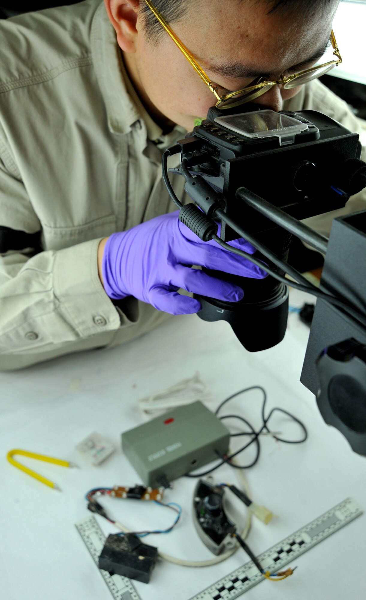 Robert Lee, United States Forces-Iraq Combined Joint Task Force Troy’s Combined Explosive Exploitation Cell Electronics Laboratory technician, takes a photograph of a disassembled improvised explosive device Dec. 8, 2010, on Camp Victory, Iraq. One key responsibility of CJTF Troy and CEXC is neutralizing the improvised explosive devices’ threat through collection and exploitation of IED evidence and related intelligence. CJTF Troy is dedicated to countering IEDs and saving lives of Iraqi and joint forces conducting Operation New Dawn. (U.S. Air Force photo by Senior Airman Andrew Lee)