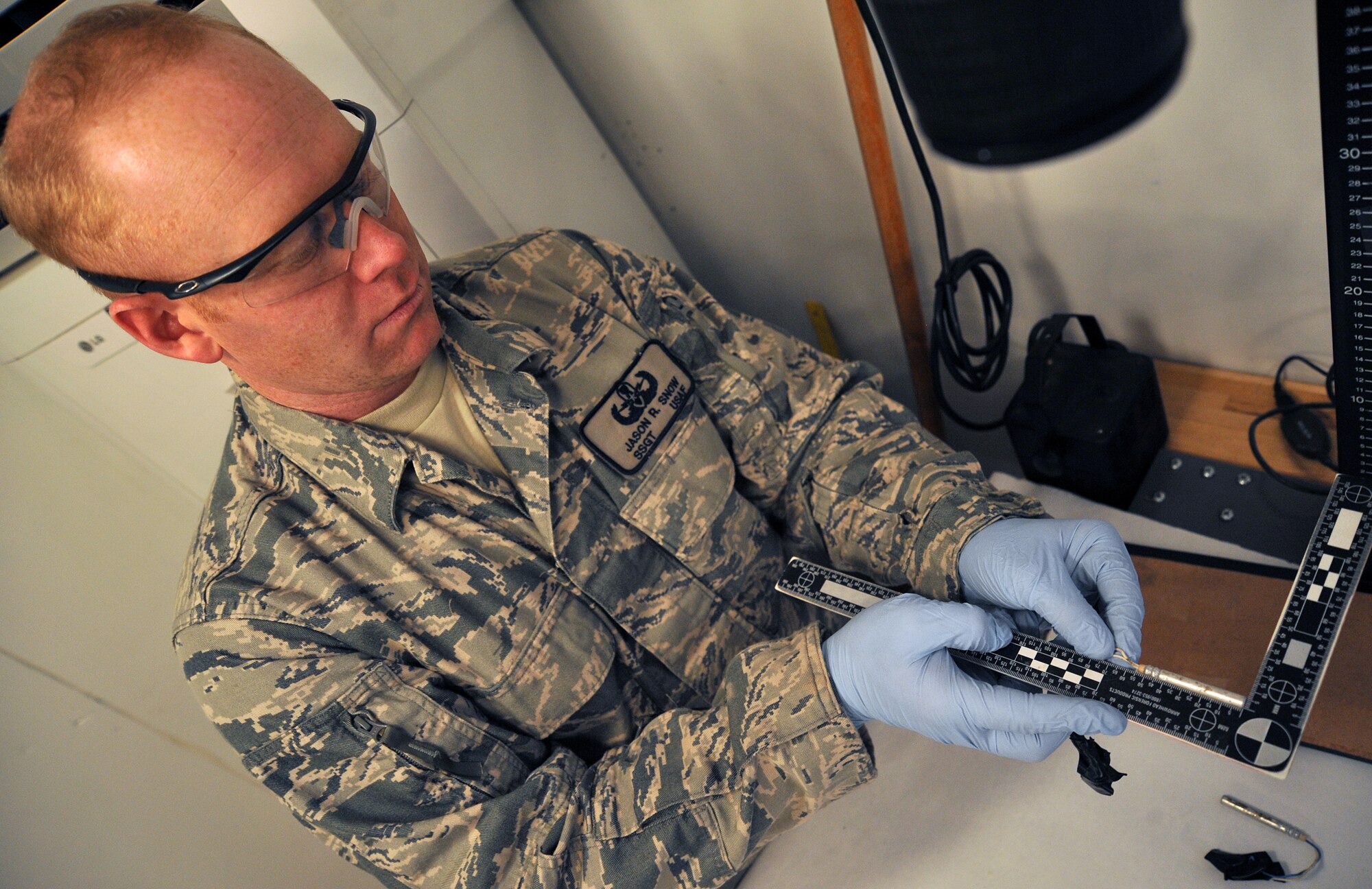 U.S. Air Force Staff Sgt. Jason Snow, United States Forces-Iraq Combined Joint Task Force Troy’s Combined Explosive Exploitation Cell Triage Laboratory non-commissioned officer in charge, holds a blasting cap beside a ruler to photograph the measurements Dec. 26, 2010, on Camp Victory, Iraq. One key responsibility of CJTF Troy and CEXC is neutralizing the improvised explosive devices’ threat through collection and exploitation of IED evidence and related intelligence. CJTF Troy is dedicated to countering IEDs and saving lives of Iraqi and joint forces conducting Operation New Dawn. (U.S. Air Force photo by Senior Airman Andrew Lee)