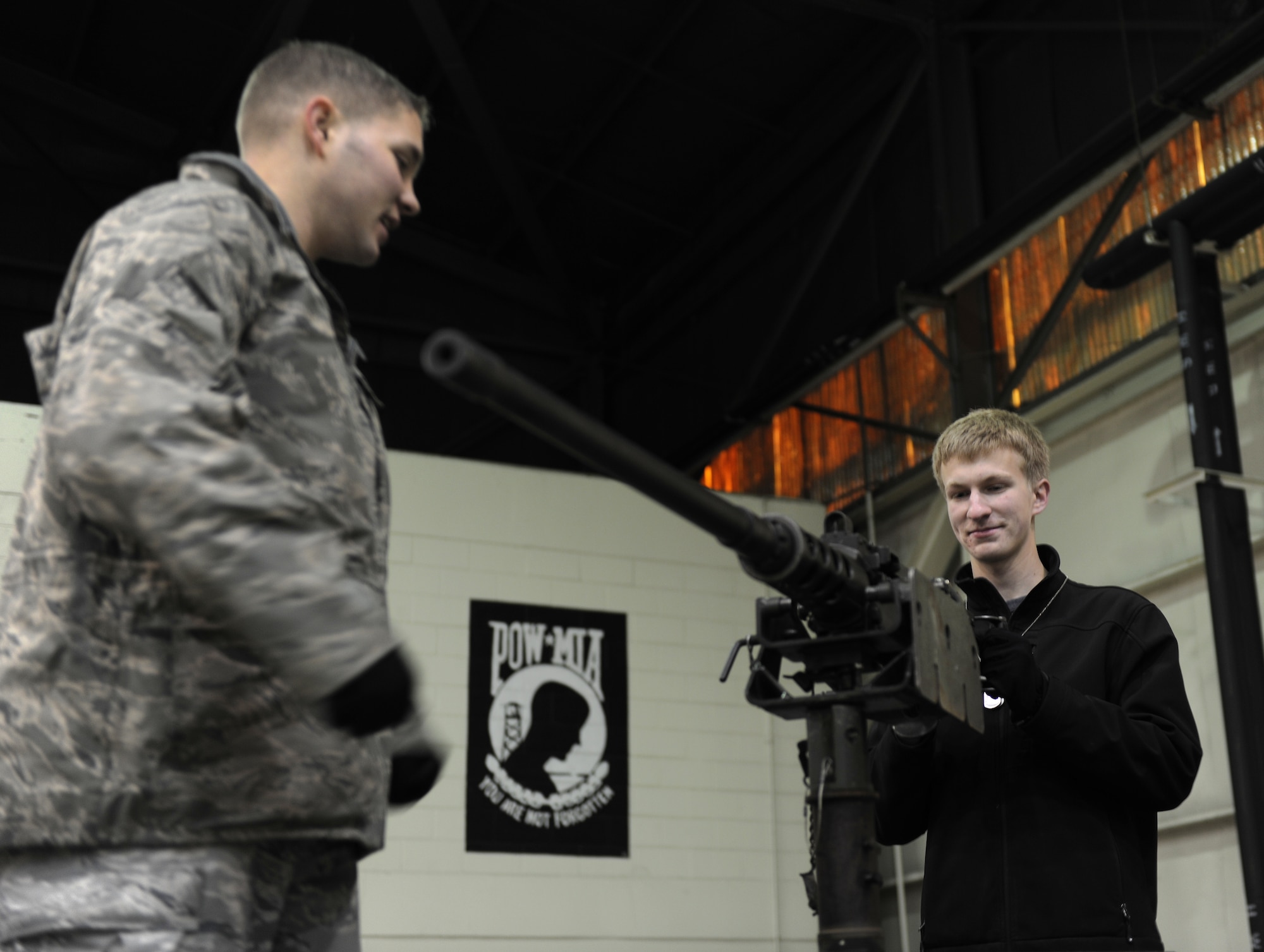 KUNSAN AIR BASE, Republic of Korea -- Staff Sgt. Andrew Caygill, 8th Security Forces Squadron, watches Chris Dolan, son of Col. John Dolan, 8th Fighter Wing commander, as he checks out an M2 .50 caliber machine gun during a family day here Dec. 27, 2010. Face painting, a military working dog demonstration and other events were offered to families visiting Kunsan during the holidays. (U.S. Air Force photo/Senior Airman Ciara Wymbs) 