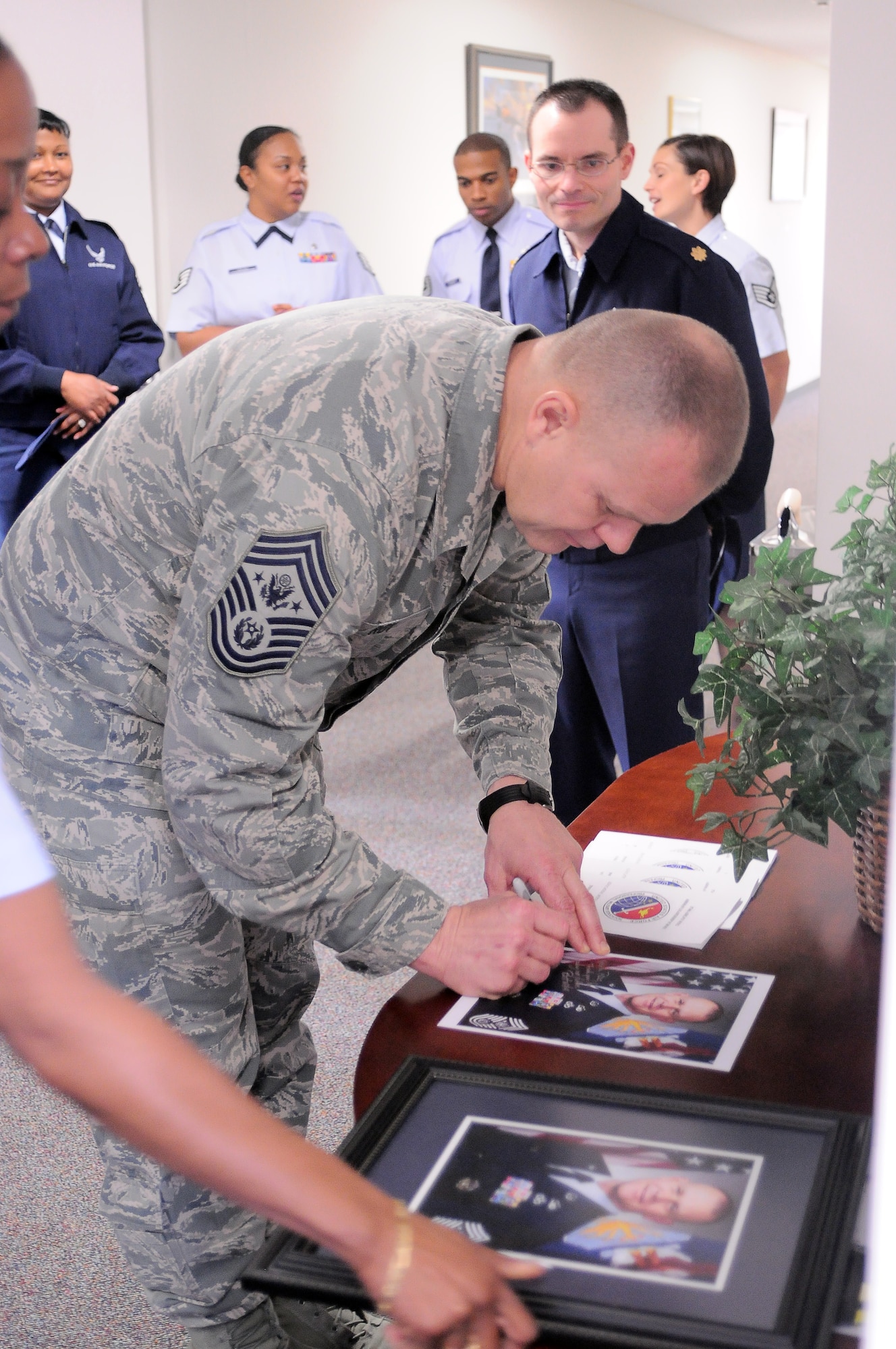 YOKOTA AIR BASE, Japan -- Chief Master Sgt. of the Air Force James Roy signs a photo of himself to hang in the hall at the Professional Development Center here, Dec. 27. Chief Roy and his wife Paula visited Yokota as part of their tour of the Pacific. (U.S. Air Force photo/ Airman 1st Class Katrina R. Menchaca)