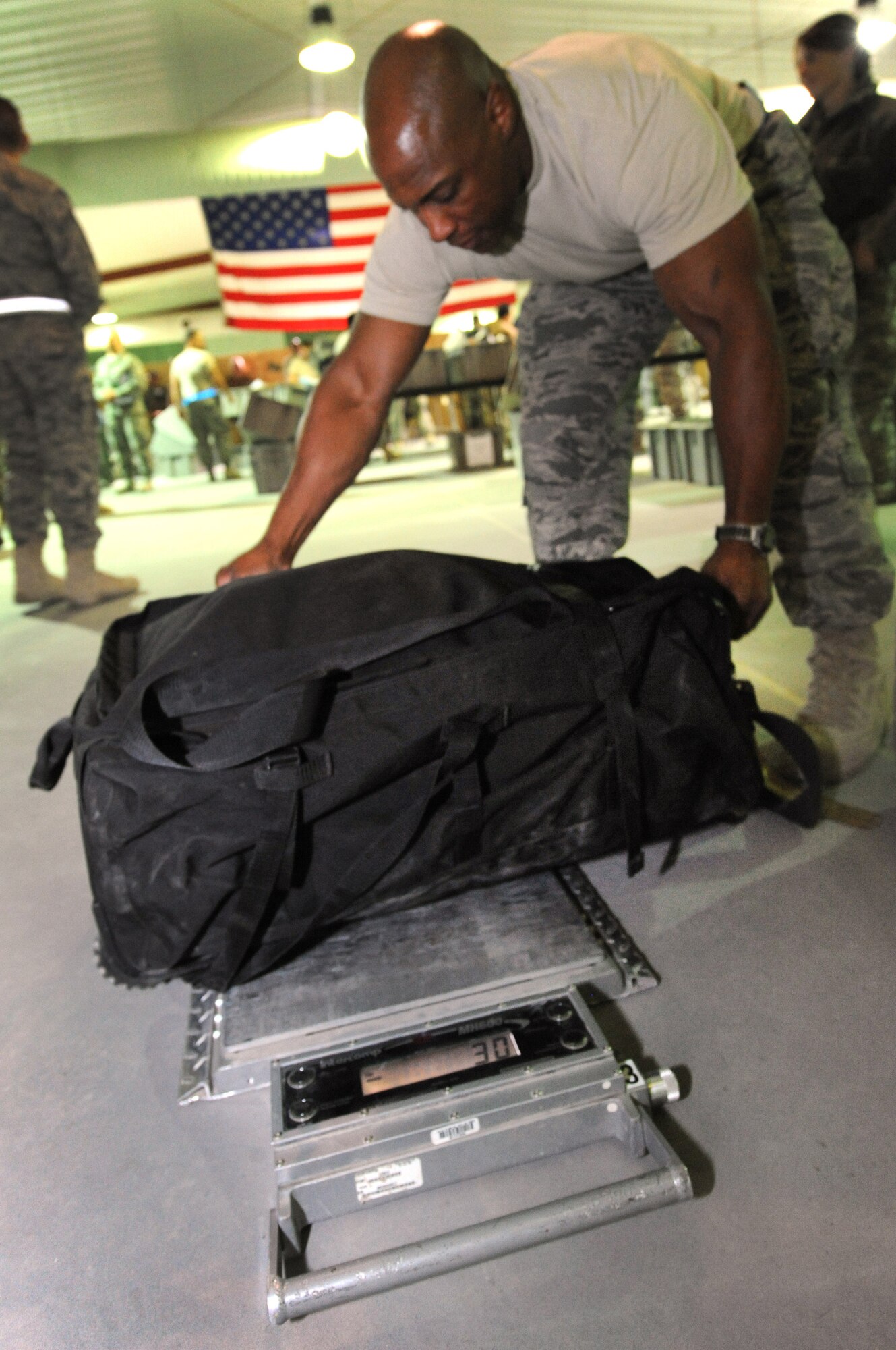 SOUTHWEST ASIA -- Master Sgt. Sean Abner checks the weight of service member’s luggage Dec. 21. The 386th Air Expeditionary Wing was able to cut down the redeployment process with the implementation of an all-Air Force customs process, with occasional Navy augmentees, a first in the Air Force Central Command area of responsibility. (U.S. Air Force photo by Senior Airman Cynthia Spalding)
