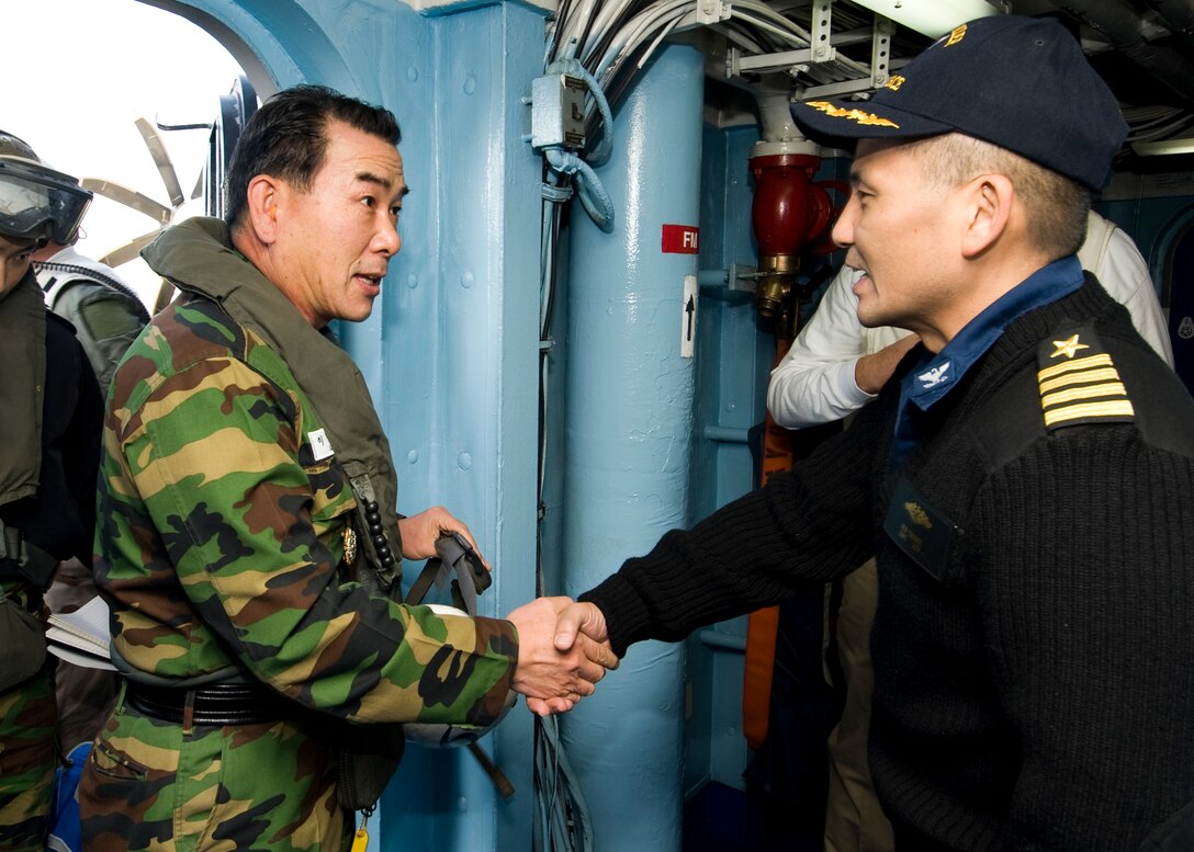 U.S. Navy Capt. Reid Tanaka, right, the chief of staff of Commander Carrier Strike Group 5, welcomes South Korean navy Rear Adm. Beom-rim Lee aboard the aircraft carrier USS George Washington while under way in the western Pacific Ocean, Nov. 28, 2010. The George Washington was participating in an exercise with the South Korean navy to reinforce the U.S. commitment to South Korean and regional partners in the western Pacific.