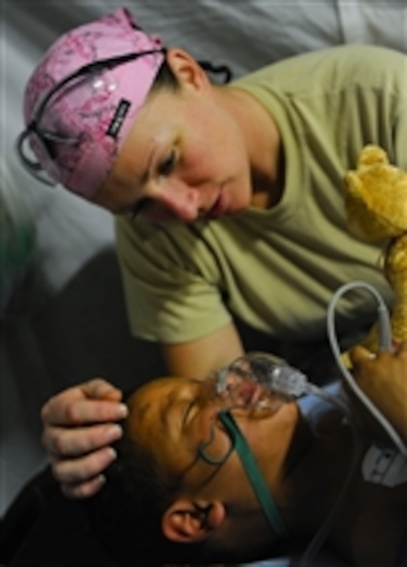 U.S. Army Staff Sgt. Virginia Andrews-Arce, a senior licensed practical nurse with the 541st Forward Surgical Team, comforts Hamed, a five-year-old Afghan boy, following surgery to repair the boy’s broken leg at Camp Pannonia, Afghanistan, on Dec. 19, 2010.  The surgical team is made up of ten members and provides surgical and resuscitative care to the Pol-e Khumri region of Afghanistan.  