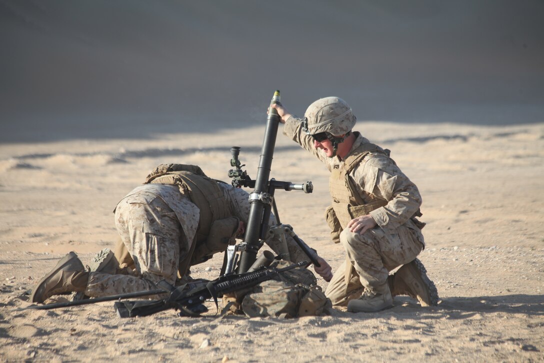 CAMP BUEHRING, Kuwait (Dec. 29, 2010) Cpl. Justin Heigold, a team leader with Weapons Platoon, Company L, Battalion Landing Team 3/8, 26th Marine Expeditionary Unit (MEU), sets the bipods for a 60mm mortar while Pfc. Ethan Thomas, an assistant gunner with Weapons Platoon, prepares to drop a round during a live-fire exercise held at Camp Buehring, Kuwait, Dec. 29. Elements of 26th MEU debarked the ships of Kearsarge Amphibious Ready Group to conduct sustainment training. (USMC photo by Sgt. Jesse J. Johnson/Released)