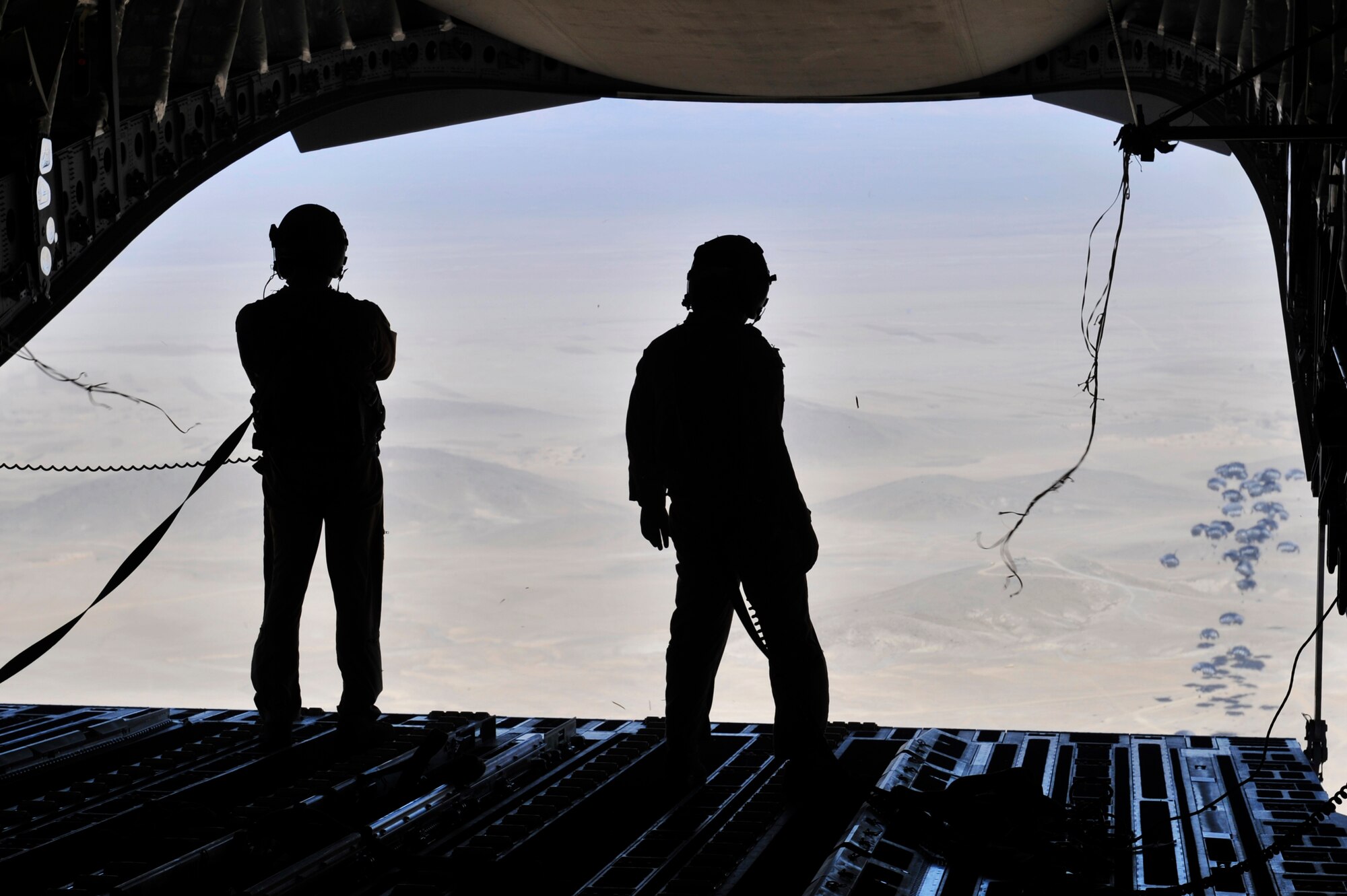 Left to right: Staff Sgts. Paul Trowbridge and Jason Fatjo, C-17 Globemaster III loadmasters, watch bundles of fuel parachute towards the ground over Afghanistan, Dec. 10, 2010.  The Globemaster fleet has surpassed 2 million flying hours since production began in 1993.  The airframe accumulated 1 million flying hours between 1993 and 2006. (U.S. Air Force photo/Staff Sgt. Christopher Boitz)