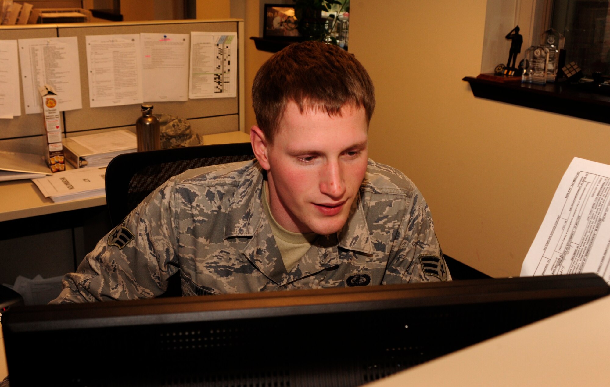 Senior Airman Jesse Hughes, 62nd Comptroller Squadron, remains focused during a busy day at work Dec. 16 at McChord Field, Joint Base Lewis-McChord, Wash. He was recently named Air Mobility Command's Financial Management Airman of the Year. (U.S. Air Force photo/Airman Leah Young)