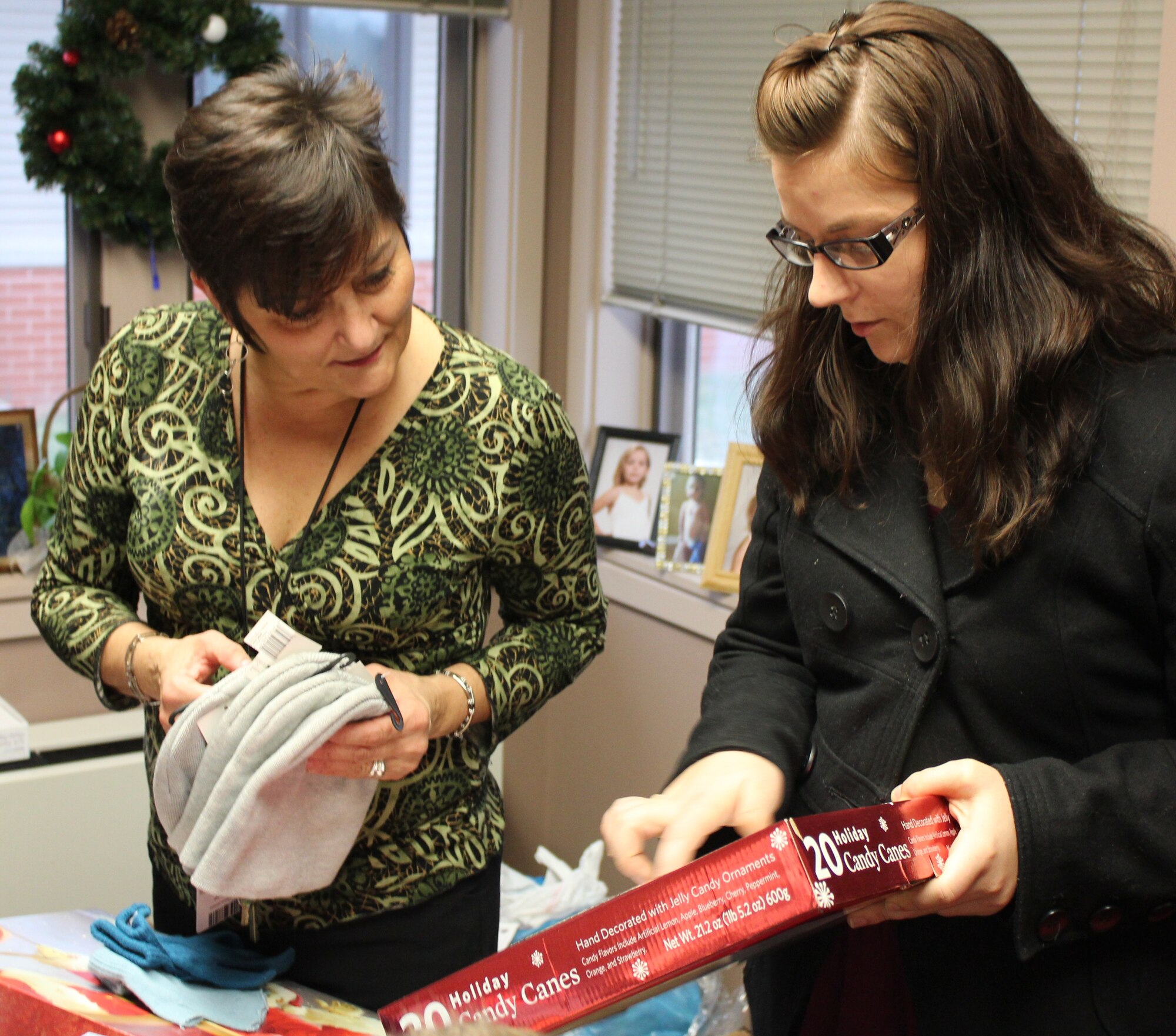 Staff Sgt. Heather Johnson, (right) shows Becky Johnston of the Missouri Veterans Home, several gifts that 932nd Airlift Wing members donated to the veterans. Sergeant Johnson, secretary of the Rising Six,  distributed clothing, candy and cookies just before Christmas.  Wing members donated more than $200 which was used to buy winter gloves, hats and other items.  This marks the second year that the 932nd AW Rising Six enlisted organization has provided gifts and vistited veterans at the facility in St. Louis, Mo.  (U.S. Air Force photo/Tech. Sgt. Dan Oliver) 