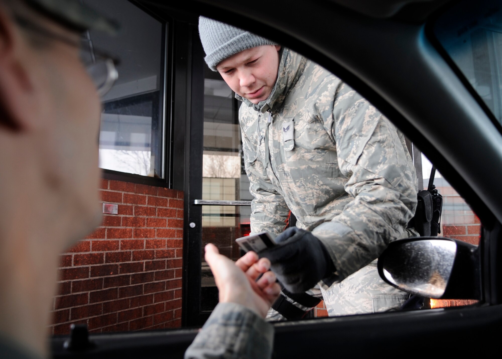 Senior Airman John Hughes, 92nd Security Forces Squadron, checks an ID at the front gate at Fairchild Air Force Base on December 29, 2010. (U.S. Air Force photo/A1C Taylor Curry)