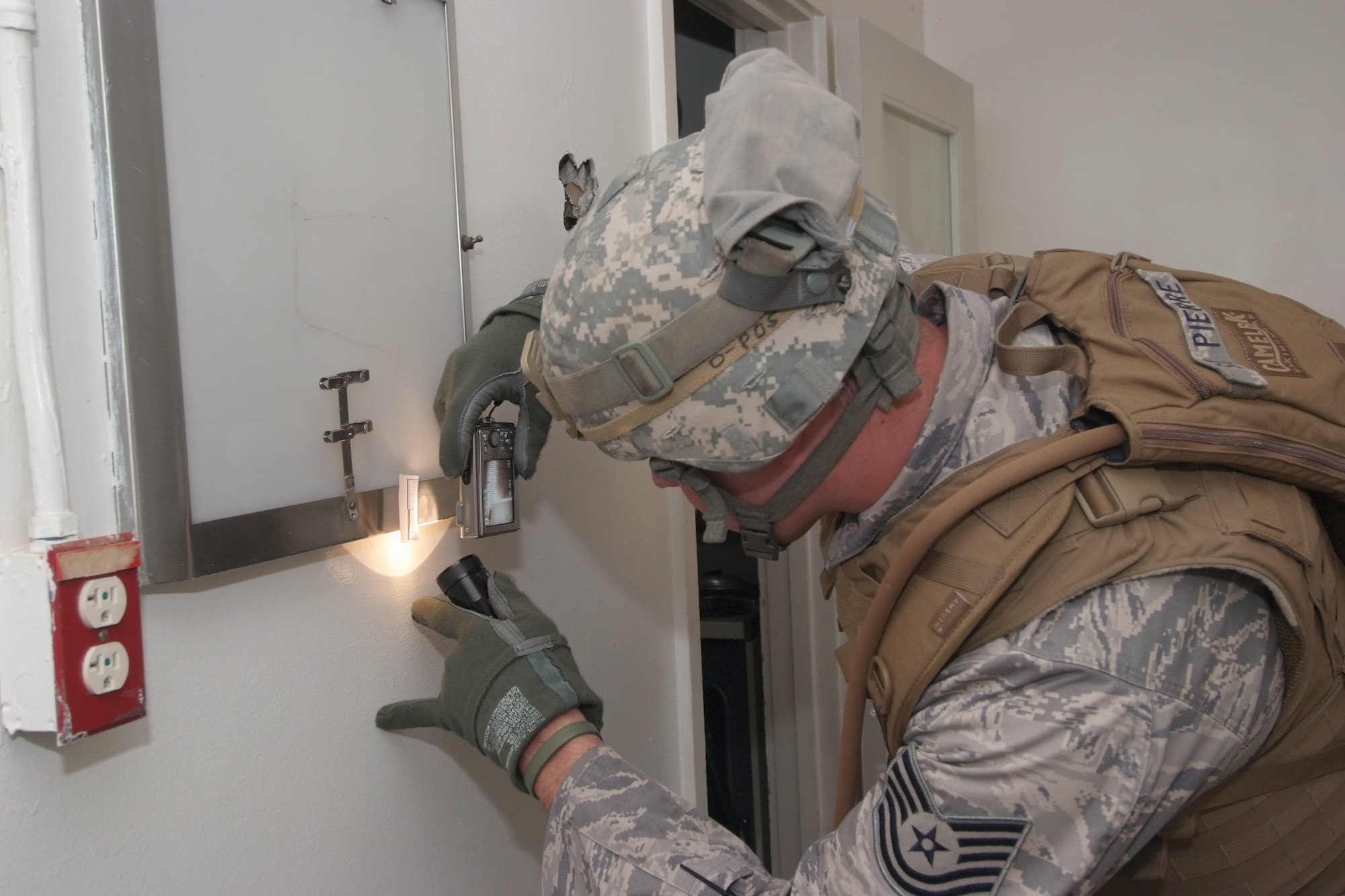 Tech. Sgt. Daniel St. Pierre takes a photograph of a piece of evidence during a battlefield forensics course at March Air Reserve Base, Calif. Sergeant St. Pierre is a member of the 4th Combat Camera Squadron. (U.S. Air Force photo/Tech. Sgt. Joseph Zuccaro) 