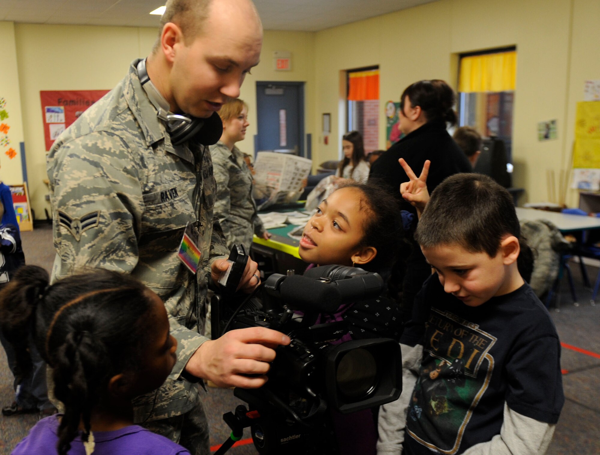 Airman 1st Class John Raven, 375th Public Affairs broadcast journalist, shows children at the Scott Air Force Base Youth Center how his video camera works Dec. 29. The Youth Center invited the Public Affairs team to come visit and talk about their job while also giving the children some hands on learning with the equipment. (U.S. Air Force photo/Staff Sgt. Ryan Crane)
