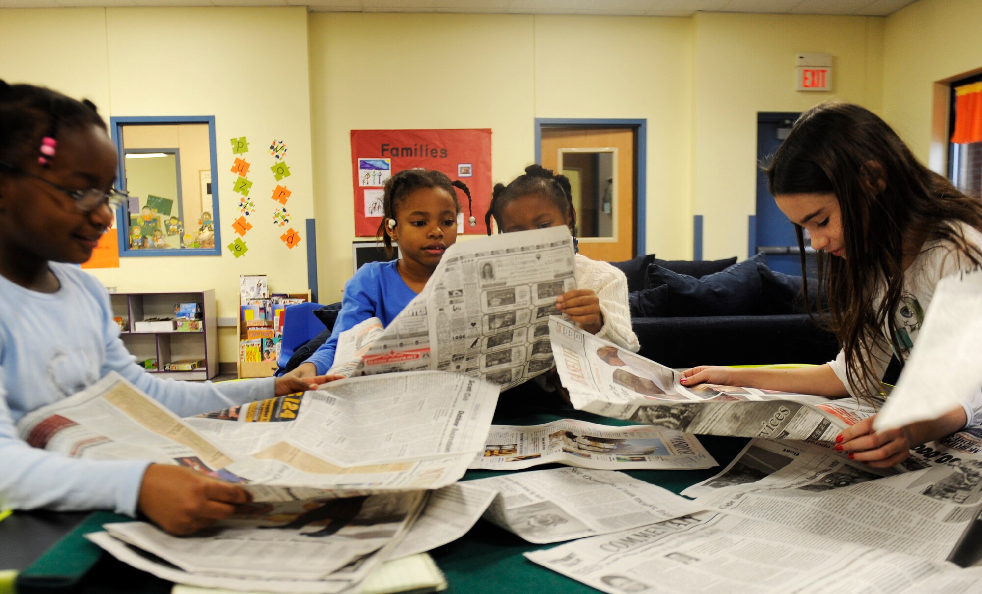 Children at the Scott Air Force Base Youth Center read through the base newspaper Dec. 29. The Youth Center invited the Public Affairs team to come visit and talk about their job while also giving the children some hands on learning with the equipment. (U.S. Air Force photo/Staff Sgt. Ryan Crane)
