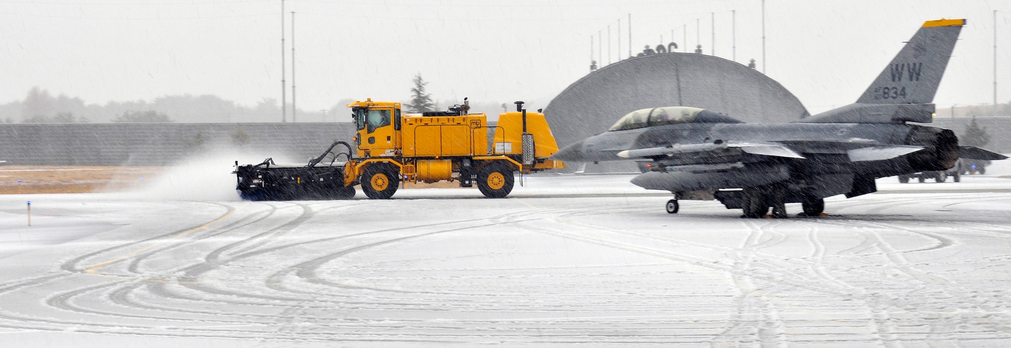 Members of the 35th Civil Engineer Squadron snow removal team clear freshly fallen snow from the 35th Fighter Wing's taxiways, ensuring  safe ground passage for Misawa's Fighting Falcon fleet Dec. 29, 2010; Misawa Air Base.  The snow removal team uses a variety of specialized equipment ranging from large mobile brushes and blowers to high-speed plows to sweep, blow and scrape snow from pavements, ensuring mission success. (U.S. Air Force photo by Tech. Sgt. Phillip Butterfield/Released)

