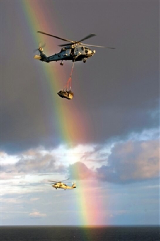 HH-60H Sea Hawk helicopters assigned to Helicopter Anti-Submarine Squadron 15 pass a rainbow while delivering mail to the aircraft carrier USS Carl Vinson during a vertical replenishment in the Pacific Ocean, Dec. 24, 2010. Carl Vinson and Carrier Air Wing 17 are on a deployment to the U.S. 7th and U.S. 5th Fleet areas of responsibility.