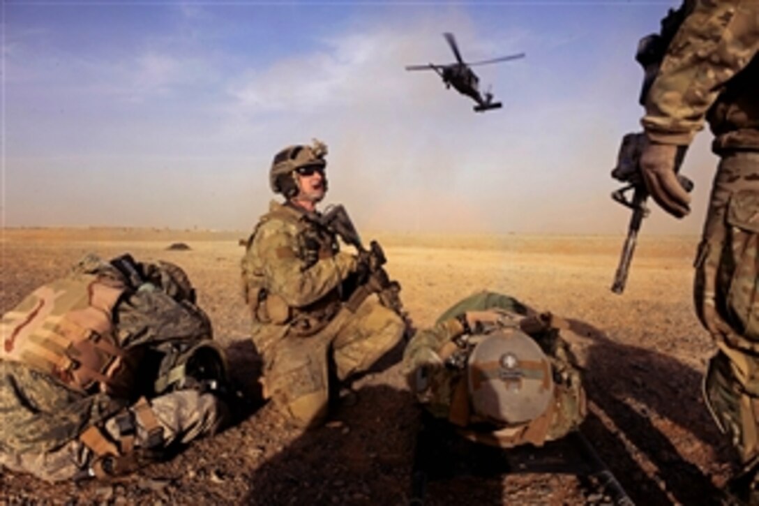 U.S. Air Force Tech. Sgt. Anthony Wood and Capt. Nick Morgans prepare to load simulated casualties as an HH-60 Pave Hawk helicopter lands during a mass casualty scenario near Kandahar, Afghanistan, on Dec. 24, 2010.  Wood and Morgans are assigned to the 46th Expeditionary Rescue Squadron.  
