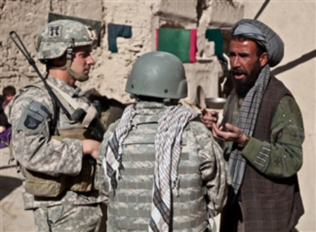 U.S. Army Staff Sgt. Christopher Lang (left), a platoon sergeant with 2nd Platoon, Angel Company, 3rd Battalion, 187th Infantry Regiment, asks an Afghan man (right) a series of questions during Operation Angel Strike 12 in Sangar, Afghanistan, on Dec. 15, 2010.  The purpose of the operation was to search for insurgents and improvised explosive device materials.  
