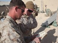 Sgt. David Doty, a squad leader with 1st Platoon, India Company, 3rd Battalion, 5th Marine Regiment, shows his platoon’s solar energy data to Maj. Sean Sadlier, the Expeditionary Energy Liaison Officer, with Regional Command Southwest, at Patrol Base Sparks in Sangin District, Dec. 29, 2010. The Marines and sailors of ‘I’ Company, 3/5, have been testing the Experimental Forward Operating Base solar energy devices since pre-deployment training in July. “Our generators typically use more than 20 gallons of fuel a day. We are down to 2.5 gallons a day,” said Doty, a Fulton, Mo., native. “The system works amazing. By saving fuel for generators, it has cut back on the number of convoys, meaning fewer opportunities for one of our vehicles to hit an IED.”