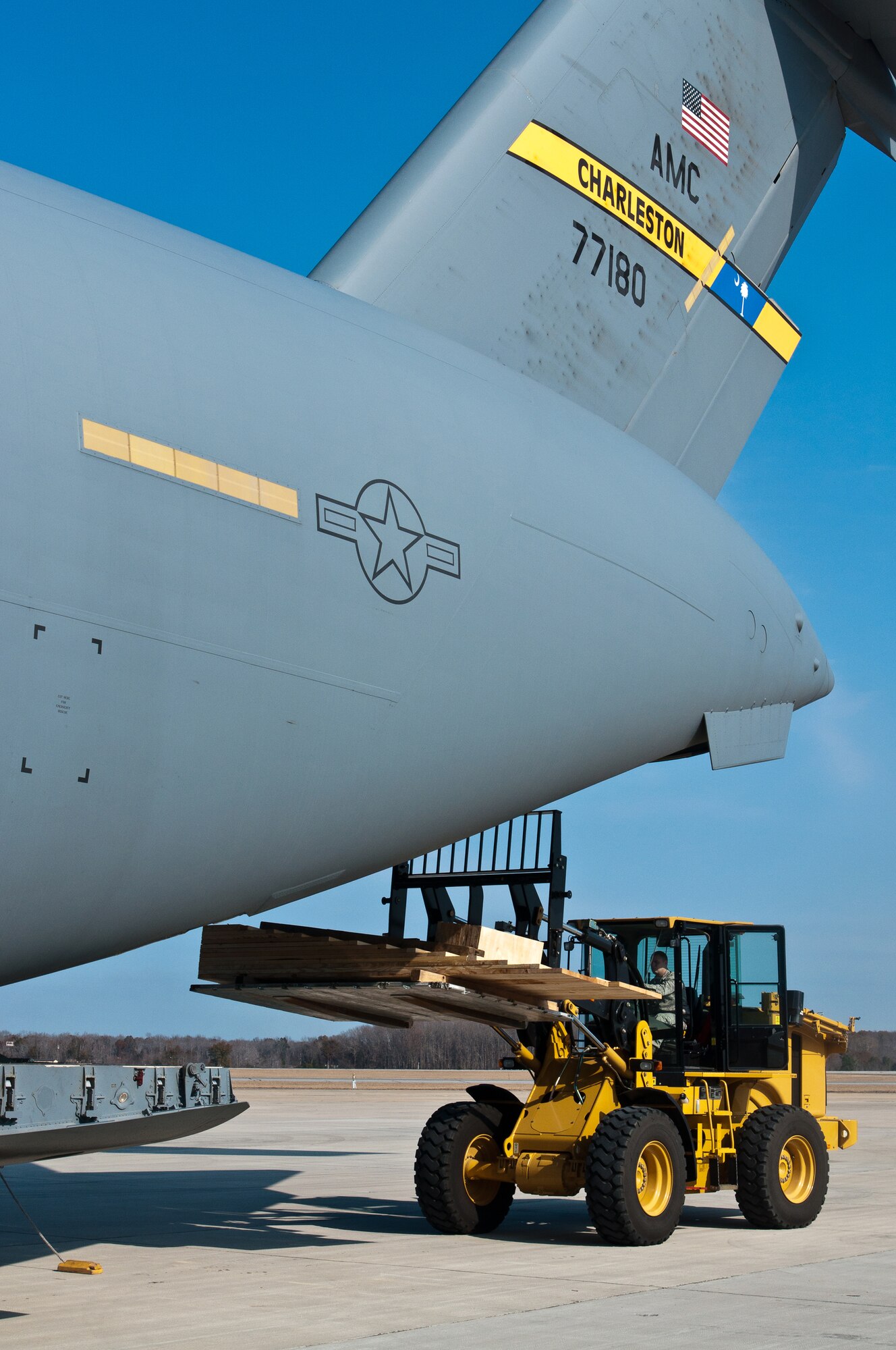 A wooden ramp used to drive a fire truck on board is loaded into a C-17 Globemaster III from the Air Force Reserve's 315th Airlift Wing, Charleston, S.C. The 315th AW C-17 landed Dec. 30, 2010, at Robins Air Force Base, Ga., to pick up humanitarian aid bound for Managua, Nicaragua. A 1984 E-One fire truck and medical supplies, totaling nearly 3.5 tons, was donated by Emergency Response Services for Latin America to assist countries in Latin America. (U.S. Air Force photo/Staff Sgt. Alexy Saltekoff)