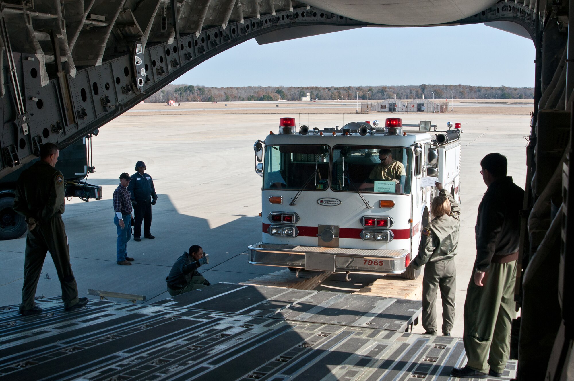 Jim McIlrath, Christ United Methodist Church pastor, Warner Robins, Ga., drives a donated fire truck into the belly of a C-17 guided by members of the Air Force Reserve's 315th Airlift Wing, Charleston, S.C. The 315th AW C-17 landed Dec. 30, 2010, at Robins Air Force Base, Ga., to pick up humanitarian aid bound for Managua, Nicaragua. A 1984 E-One fire truck and medical supplies, totaling nearly 3.5 tons, was donated by Emergency Response Services for Latin America to assist countries in Latin America. (U.S. Air Force photo/Staff Sgt. Alexy Saltekoff)