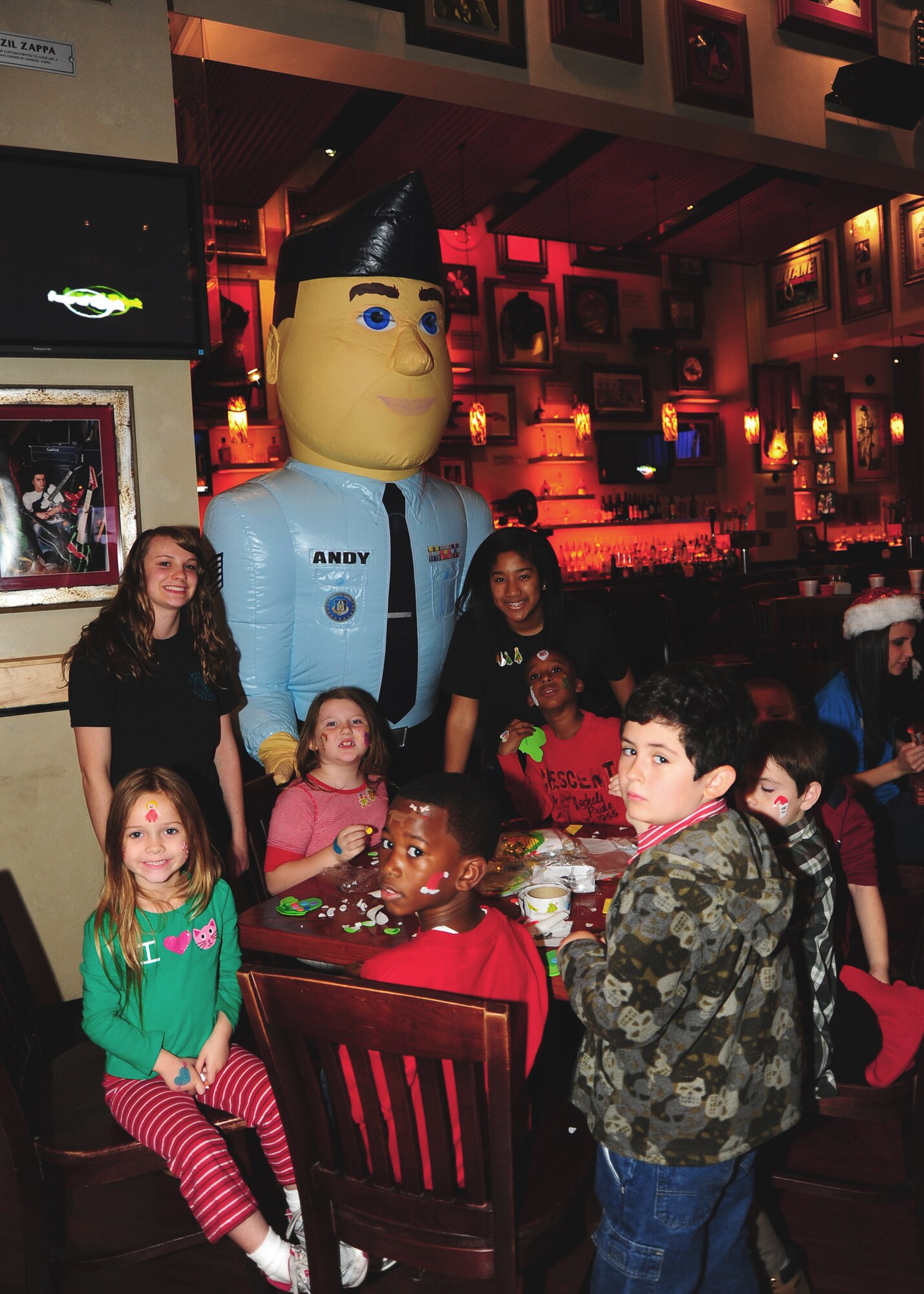 Airman Andy takes a moment to pose with children at Hard Rock Cafe during a recent recruiting event.  From the left: Olivia Kommer Smith, Emma Graham, Alexander Green, Zavier Dean,  Elisha Merkel, Corey Duglas, Garret Silverstein and Willie Reed.(U.S. Air Force photo by Staff Sgt. Yolanda Addison)