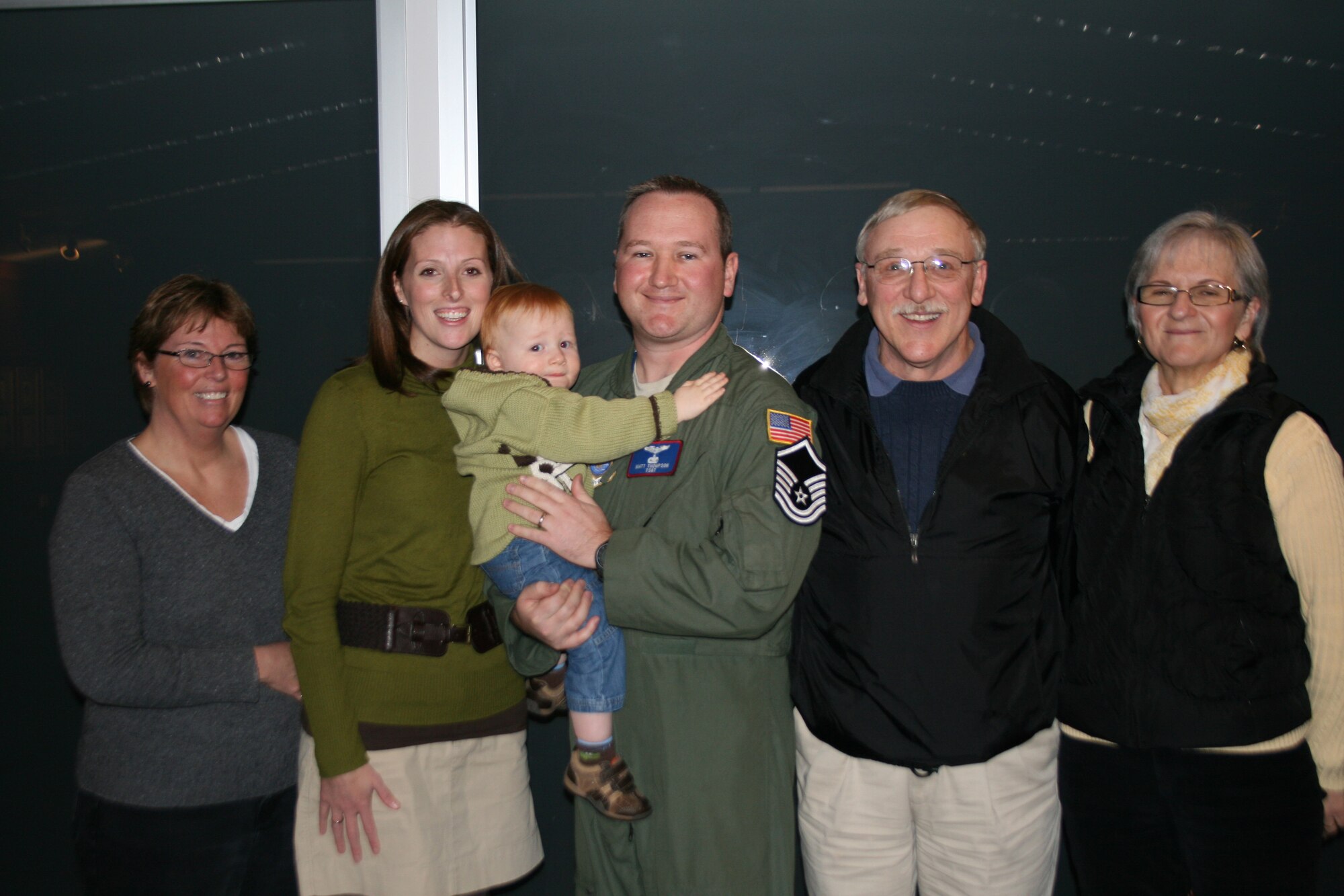 Newly minted Master Sgt. Matt Thompson, center, 4th Airlift Squadron, spends time with family after being STEP promoted by Col. Kevin Kilb, 62nd Airlift Wing commander, in front of his squadron members. (U.S. Air Force courtesy photo)