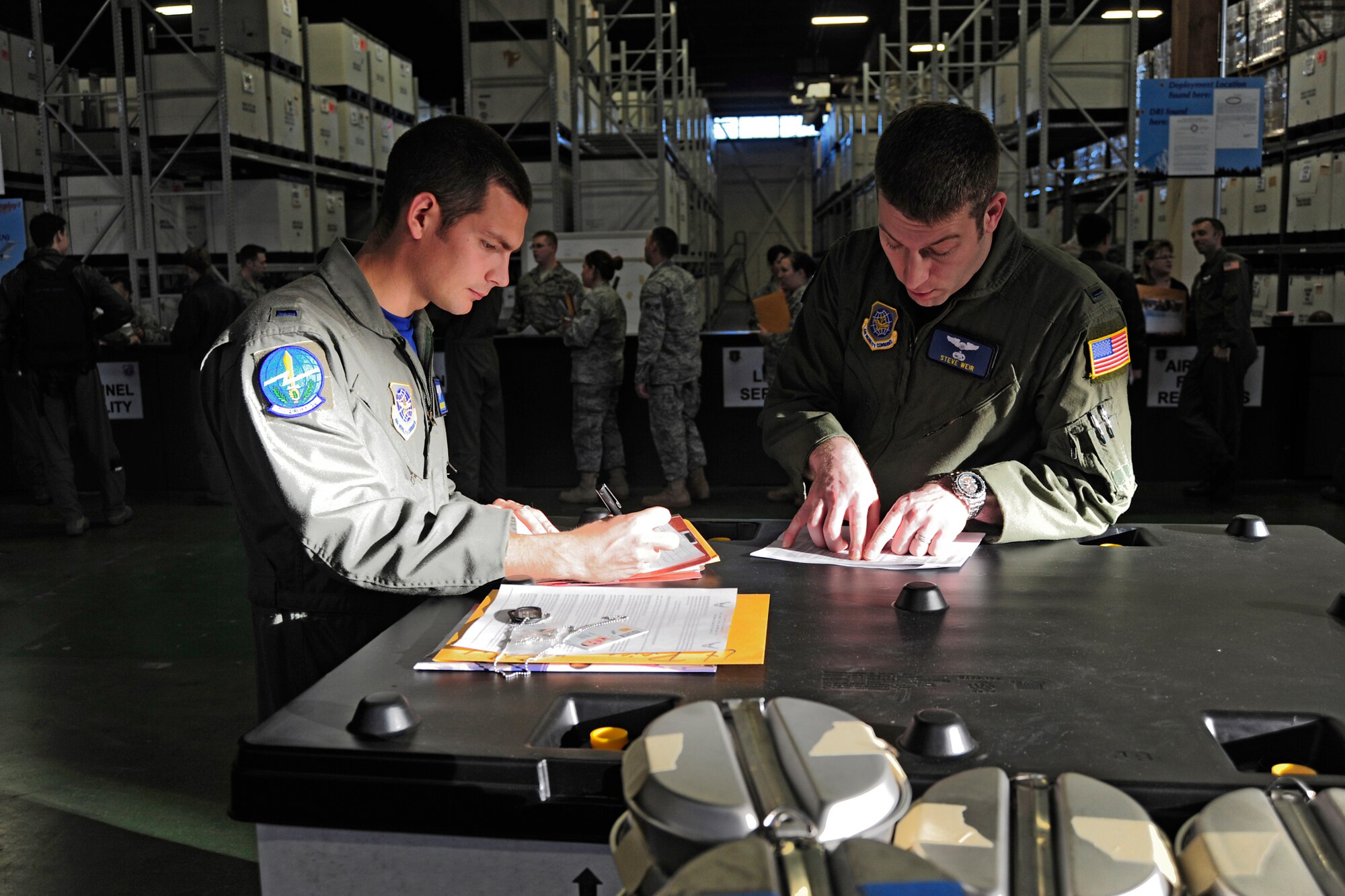1st Lt. Michael Price, left, and 1st Lt. Stephen Weir, both 7th Airlift Squadron pilots, review paperwork after passing through the deployment processing line Dec. 23 at McChord Field, Joint Base Lewis-McChord, Wash. (U.S. Air Force photo/Adamarie Lewis-Page)