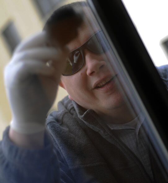 BARKSDALE AIR FORCE BASE, La. - Lead criminal investigator, Monte Jones, 2nd Security Forces Squadron, dusts for fingerprints at a crime scene located at Barksdale Air Force Base, La., Dec. 29. When dusting for fingerprints, investigators use fingerprint powder, brushes and hinge lifters to collect prints for further investigation. (U.S. Air Force photo/Senior Airman Alexandra M. Boutte) (RELEASED) 