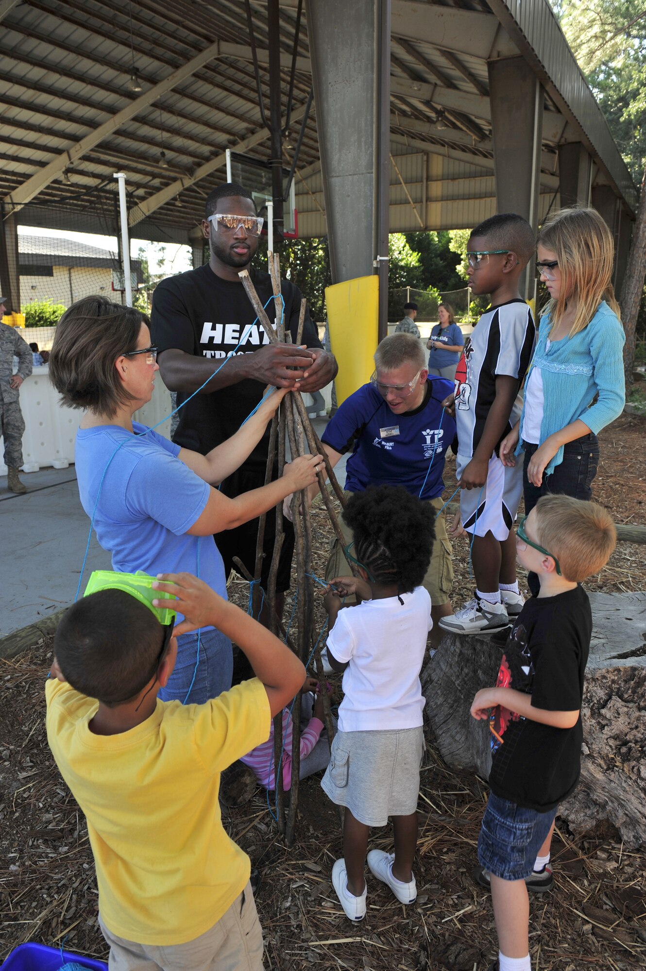 Dwayne Wade works on a team building activity with children at the outdoor classroom at the youth center Sept. 30, 2010, at Hurlburt Field Fla. In November 2009 the classroom became the 29th Arbor Day Foundation and Dimensions Educational Research Foundation-certified Nature Explore classroom in the country. Mr. Wade is player for the NBA's Miami HEAT. (U.S. Air Force photo/Staff Sgt. Stephanie Jacobs)