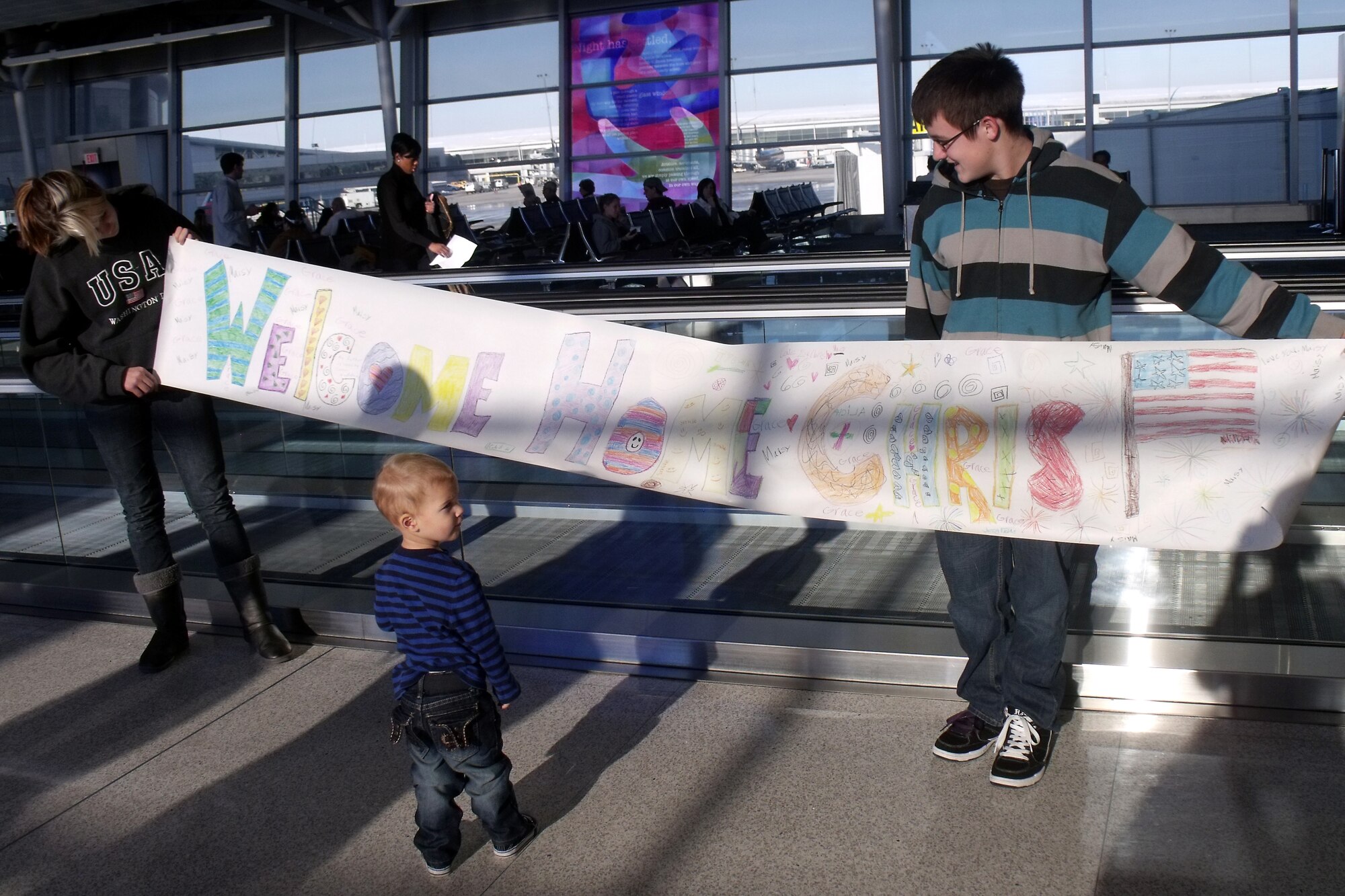 GRISSOM AIR RESERVE BASE, Ind. -- Family members of Staff Sgt. Christopher Bauchle, 434th Civil Engineer Squadron firefighter, hold a banner up as they wait for him at Indianapolis International Airport. Sergeant Bauchle and four other 434th CES firefighters returned from a recent deployment to Southwest Asia Dec. 23. (U.S. Air Force photo/Senior Airman Jamia Nalls)
