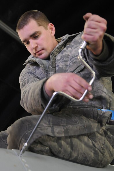 SPANGDAHLEM AIR BASE, Germany – Staff Sgt. Ryan Merrill, 480th Aircraft Maintenance Unit dedicated crew chief, uses a speed handle to open the panel of an F-16 Fighting Falcon during a “cannibalization bird” process Dec. 30. The cann-bird process is a maintenance process in which one aircraft is taken apart to supply mission capable parts that will be used by remaining aircraft in the fleet. (U.S. Air Force photo/Senior Airman Nick Wilson)