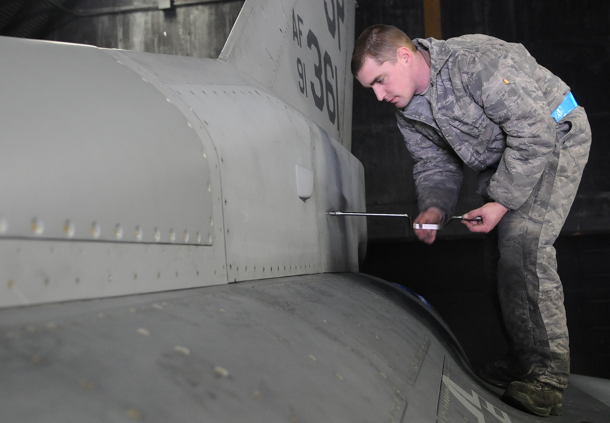 SPANGDAHLEM AIR BASE, Germany – Staff Sgt. Ryan Merrill, 480th Aircraft Maintenance Unit dedicated crew chief, uses a speed handle to open the panel of an F-16 Fighting Falcon during a “cannibalization bird” process Dec. 30. The cann-bird process is a maintenance process in which one aircraft is taken apart to supply mission capable parts that will be used by remaining aircraft in the fleet. (U.S. Air Force photo/Senior Airman Nick Wilson)