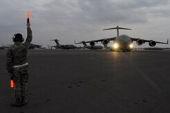 Air Force Brig. Gen. Carlton D. Everhart II taxis the newest C-17 Globemaster III aircraft as Airman 1st Class Daniel Torrio clears the wing tips on the Joint Base Charleston, S.C., flightline Dec. 22, 2010. The arrival of the aircraft brings the total number of C-17s assigned to the 437th Airlift Wing to 59. General Everhart is the 618th Air and Space Operations vice commander and Airman Torrio is assigned to the 437th Aircraft Maintenance Squadron. (U.S. Air Force photo/Staff Sgt. Marie Brown)
