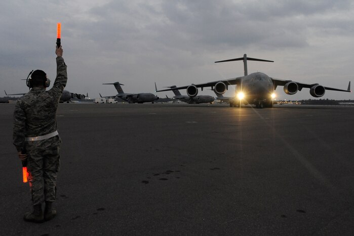 Air Force Brig. Gen. Carlton D. Everhart II taxis the newest C-17 Globemaster III aircraft as Airman 1st Class Daniel Torrio clears the wing tips on the Joint Base Charleston, S.C., flightline Dec. 22, 2010. The arrival of the aircraft brings the total number of C-17s assigned to the 437th Airlift Wing to 59. General Everhart is the 618th Air and Space Operations vice commander and Airman Torrio is assigned to the 437th Aircraft Maintenance Squadron. (U.S. Air Force photo/Staff Sgt. Marie Brown)