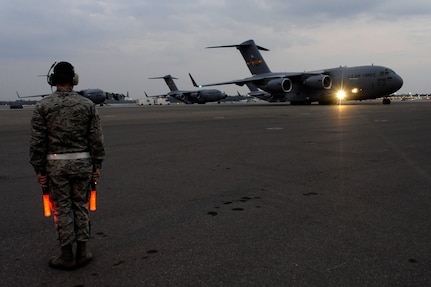 Air Force Brig. Gen. Carlton D. Everhart II taxis in a new C-17 Globemaster III aircraft as Airman 1st Class Daniel Torrio prepares to clear the wing tips on the Joint Base Charleston, S.C., flightline Dec. 22, 2010. The arrival of the aircraft brings the total number of C-17s assigned to the 437th Airlift Wing to 59. General Everhart is the 618th Air and Space Operations vice commander and Airman Torrio is assigned to the 437th Aircraft Maintenance Squadron. (U.S. Air Force photo/Staff Sgt. Marie Brown)