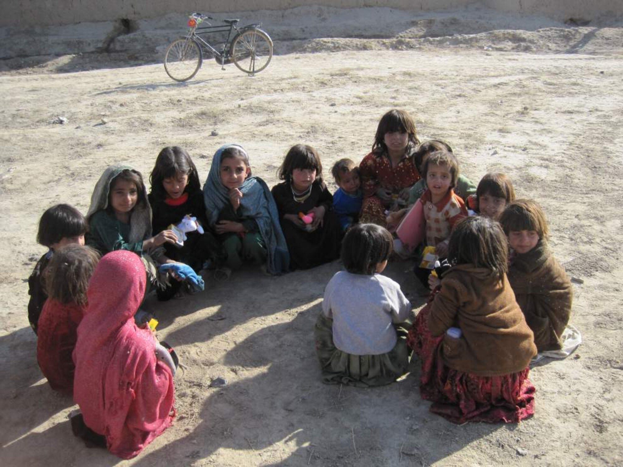 BAGRAM AIR BASE, Afghanistan -- Local Afghani children enjoy their new toys and crayons provided by 1st Lt. Evan Kelly, deployed from the 56th Rescue Squadron at RAF Lakenheath, England. The toys were sent by Stacey Swift of McLean, Va, who collected them from friends and families across northern Virginia. Lieutenant Kelly, an HH-60G helicopter pilot, coordinated with local Office of Special Investigations agents to deliver the toys. Both Lieutenant Kelly and Ms. Swift will continue to collect toys and provide them to local children throughout the remainder of his tour. (U.S. Air Force photo courtesy of 1st Lt. Evan Kelly)