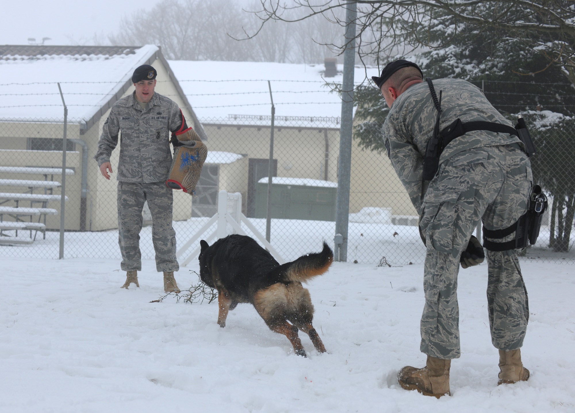 SPANGDAHLEM AIR BASE, Germany – Staff Sgt. David Simpson, 52nd Security Forces Squadron military working dog handler, gives Robson, a 5-year-old German Shepherd, the command to attack Staff Sgt. William Washer, 52nd SFS military working dog handler, during a training exercise at the 52nd SFS military working dog facility Dec. 29. Handlers play and train with their dogs in the snow to acclimate them to cold German winters and harsh conditions that they must work in. (U.S. Air Force photo/Senior Airman Nathanael Callon)