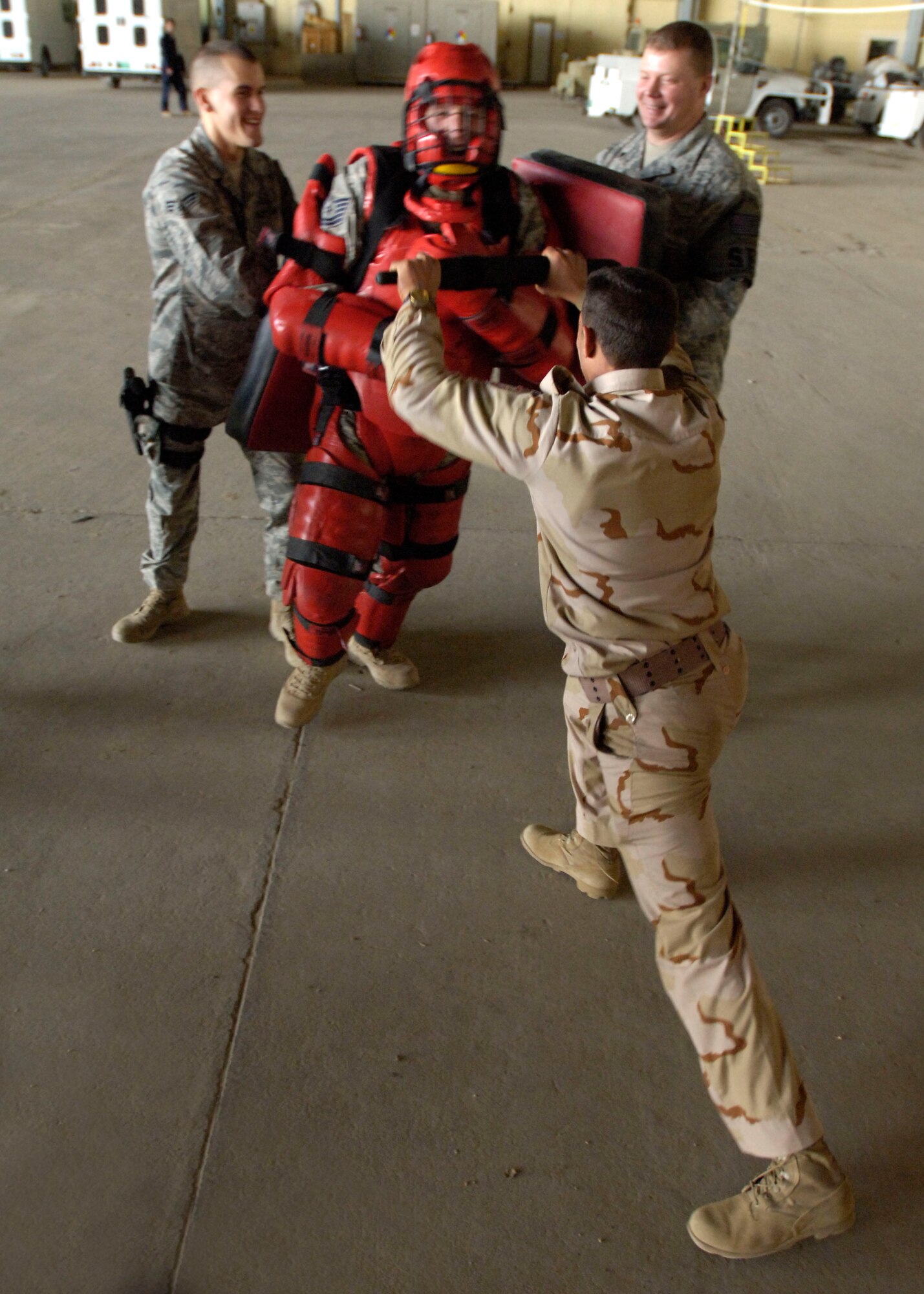 Tech Sgt. Todd Barnett, New Al-Muthana Air Base Transition Team member, attacks a member of the Iraqi Air Force during a training session Dec. 23.  The “Red Man” suit helped provide a physical assault, but prevented any serious injuries during the training.  (U.S. Air Force photo by Tech. Sgt. Randy Redman, Released)