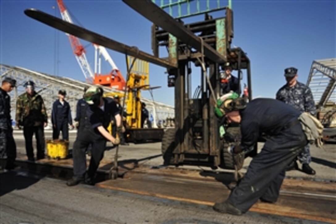 U.S. Navy sailors perform maintenance on the catapults aboard the aircraft carrier USS George Washington, off the coast of Yokosuka, Japan, Dec. 29, 2010. Since pulling out of port May 18, 2010, George Washington has traveled 51,700 nautical miles and safely launched and recovered 8,351 aircraft. The George Washington is the Navy's only permanently forward-deployed aircraft carrier, ensuring security and stability across the western Pacific Ocean. 