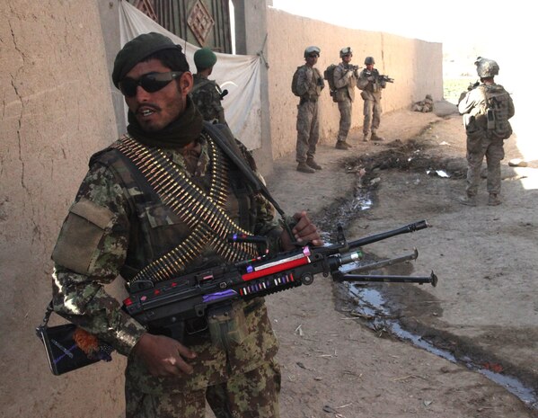 An Afghan National Army soldier provides security during a foot patrol in the Allikozai village in Sangin District, Dec. 30. Coalition forces with India Company, 3rd Battalion, 5th Marine Regiment met with village elders to deliver funds to help repair a mosque damaged by the Taliban. The Allikozai people have a known history for opposing the Taliban.