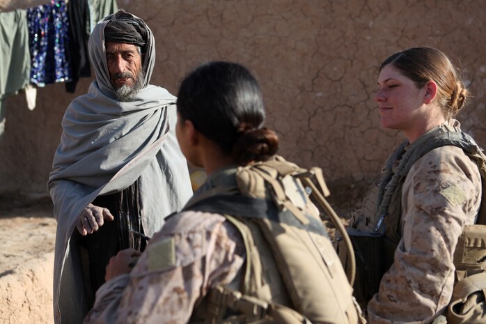 U.S. Marine Corps Sgt. Jessica Domingo, right, and Cpl. Daisy Romero, assigned to a female engagement team (FET), speak with an Afghan man in his compound during a patrol in Marjah, Helmand province, Afghanistan, Dec. 30, 2010. The FET worked with infantry Marines by engaging women and children in support of the International Security Assistance Force.