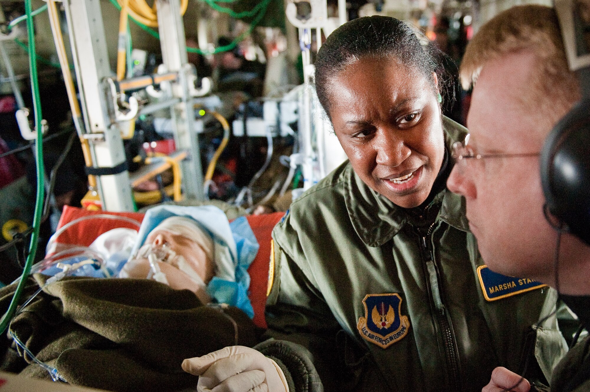 CINCINNATI, OHIO -- Capt. Marsha Starks, a nurse from the 633rd Air Base Wing at Langley Air Force Base, Va., consults with Lt. Col. David Norton about the care of a simulated patient Feb 11, 2010, while participating in an aeromedical training class over the skies of southern Ohio. Colonel Norton is director of the two-week class, designed to provide medical personnel with total immersion in the care of severely injured patients. Ground training and simulated-flight training are conducted at the University of Cincinnati, one of four Air Force Centers for Sustainment of Trauma and Readiness Skills (CSTARS) nationwide, but the final day of instruction is provided during actual flight. The Kentucky Air Guard's 165th Airlift Squadron began providing its C-130s to use as a CSTARS training platform in 2009. (U.S. Air Force by Maj. Dale Greer)