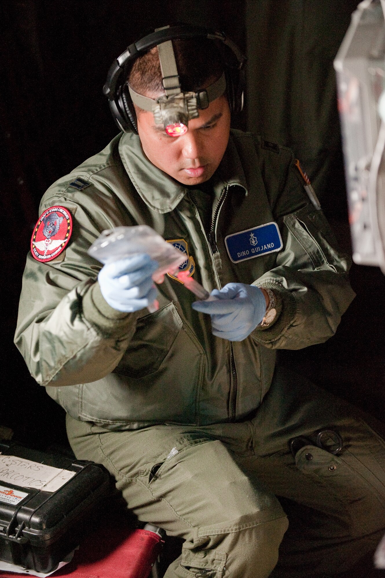 CINCINNATI, OHIO -- Capt. Dino Quijano, a nurse from the 60th Inpatient Squadron at Travis Air Force Base, Calif., prepares simulated narcotics for a training mannequin while airborne Feb 11, 2010. Captain Quijano was participating in a two-week Critical Care Air Transport Team course designed to provide medical personnel with total immersion in the care of severely injured patients. Ground training and simulated-flight training are conducted at the University of Cincinnati, one of four Air Force Centers for Sustainment of Trauma and Readiness Skills (CSTARS) nationwide, but the final day of instruction is provided while airborne in a Kentucky Air Guard C-130. Kentucky's 165th Airlift Squadron began providing C-130s to use as a CSTARS training platform in 2009. (U.S. Air Force by Maj. Dale Greer)