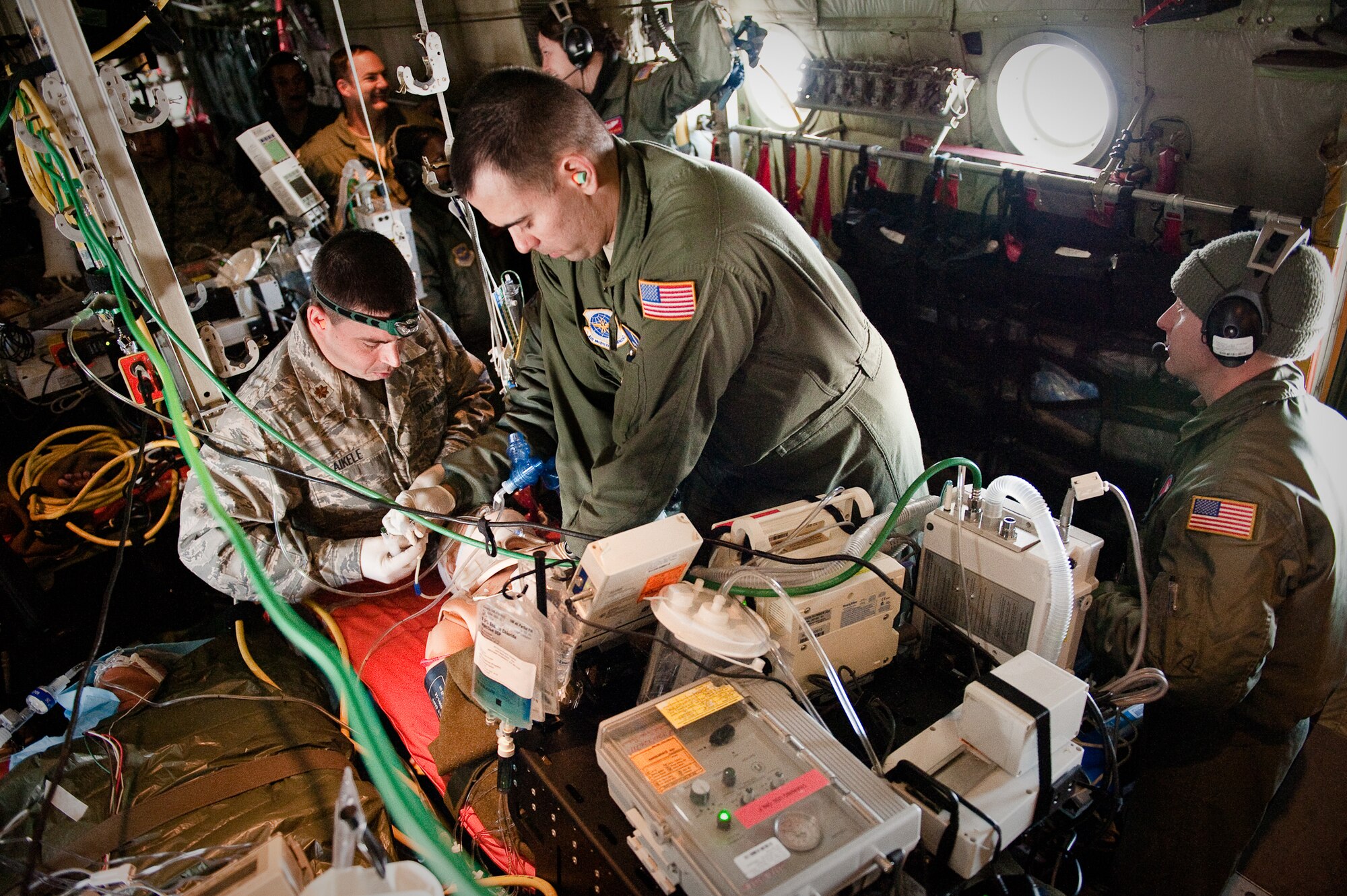 CINCINNATI, OHIO -- Maj. Samuel AiKele (left), an anesthesiologist from the 99th Medical Group at Nellis Air Force Base, Nev., and Master Sgt. James Woods, a respiratory therapist from the 60th Surgical Operations Squadron at Travis Air Force Base, Calif., perform cardio-pulmonary resuscitation on a medical-training mannequin Feb. 11, 2010, while flying over southern Ohio aboard a Kentucky Air Guard C-130. The Airmen were participating in a two-week Critical Care Air Transport Team course designed to provide medical personnel with total immersion in the care of severely injured patients. Ground training and simulated-flight training are conducted at the University of Cincinnati, one of four Air Force Centers for Sustainment of Trauma and Readiness Skills (CSTARS) nationwide, but the final day of instruction is provided during actual flight. The Kentucky Air Guard's 165th Airlift Squadron began providing C-130s to use as a CSTARS training platform in 2009. (U.S. Air Force by Maj. Dale Greer)