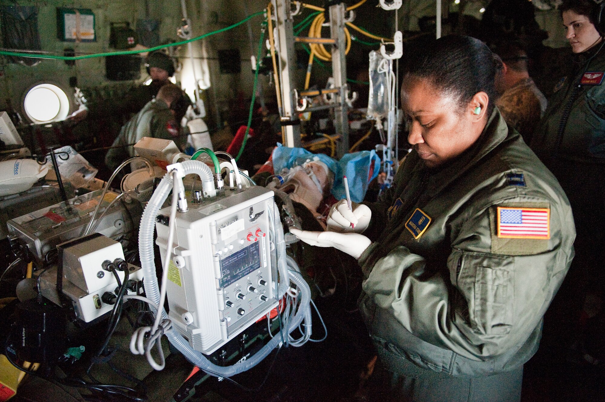 CINCINNATI, OHIO -- Capt. Marsha Starks, a nurse from the 633rd Air Base Wing at Langley Air Force Base, Va., notes the vital signs of a simulated patient while airborne Feb 11, 2010, as 1st Lt. Leann Hisle, a flight nurse from 375th Aeromedical Evacuation Squadron at Scott Air Force Base, Ill., observes. Captain Starks was participating in a two-week Critical Care Air Transport Team course designed to provide medical personnel with total immersion in the care of severely injured patients. Ground training and simulated-flight training are conducted at the University of Cincinnati, one of four Air Force Centers for Sustainment of Trauma and Readiness Skills (CSTARS) nationwide, but the final day of instruction is provided during actual flight aboard a Kentucky Air Guard C-130. Kentucky's 165th Airlift Squadron began providing C-130s to use as a CSTARS training platform in 2009. (U.S. Air Force by Maj. Dale Greer)