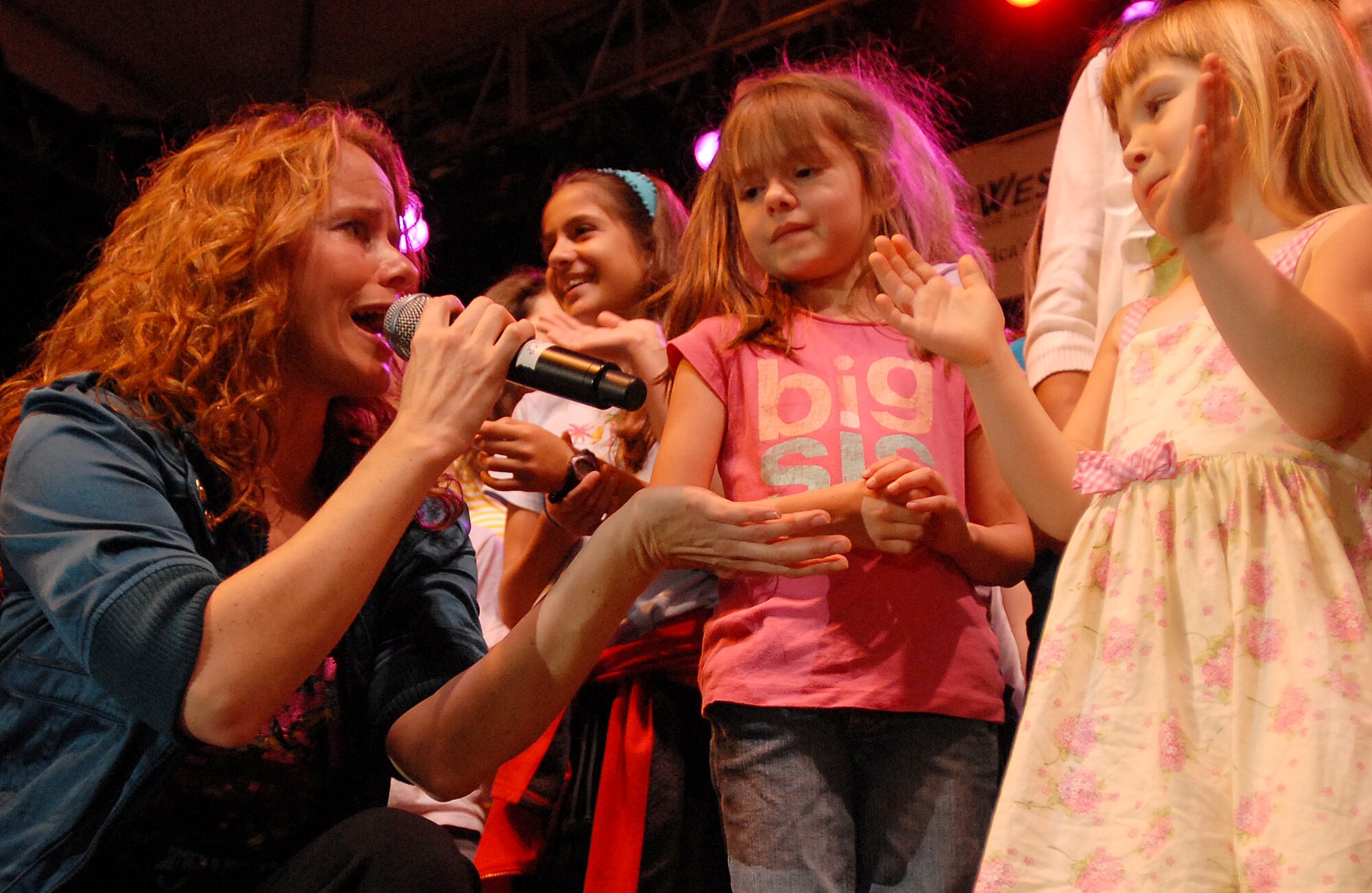 HICKAM AIR FORCE BASE, Hawaii -- Julie Dutchak, Lt. Dan Band vocalist, sings to a young visitor on stage during the Patty Labelle?s song Lady Marmalade at the Gary Sinise and the Lt. Dan Band concert Jan. 30 at Freedom Tower. The band performed songs such as Lynard Skynard?s Sweet Home Alabama, Jimi Hendrix Purple Haze and Led Zeppelin?s Rock and Roll. More than 4,000 people were on hand for the USO and Triwest sponsored concert. (U.S. Air Force photo/Staff Sgt. Mike Meares)