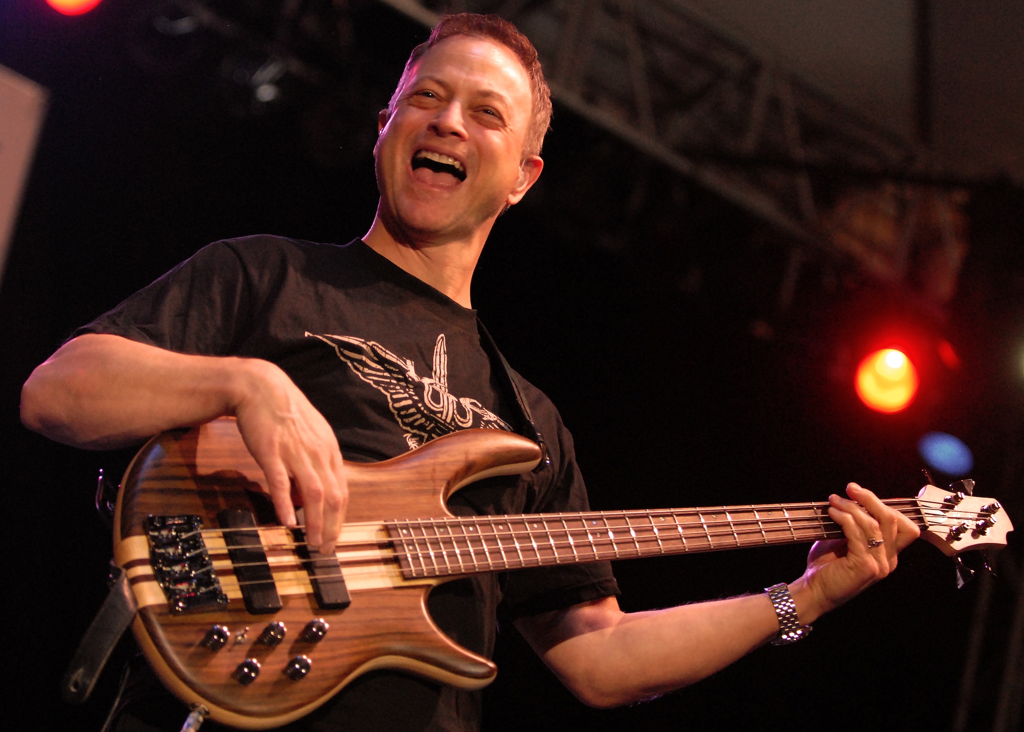 HICKAM AIR FORCE BASE, Hawaii -- Gary Sinise, bass guitarist for the Lt. Dan Band, performs for more than 6,000 Hickam and Pearl Harbor service members at Freedom Tower Jan. 30. The Lt. Dan Band covers everything from Springsteen to Linkin Park, from Aretha Franklin to Jimi Hendrix.  The concert is sponsored by USO and Triwest. The band is known for a character Sinise portrayed in the 1994 Academy Award winning film, Forrest Gump. Sinise received an Oscar nominated for Best Supporting Actor. (U.S. Air Force photo/Staff Sgt. Mike Meares)