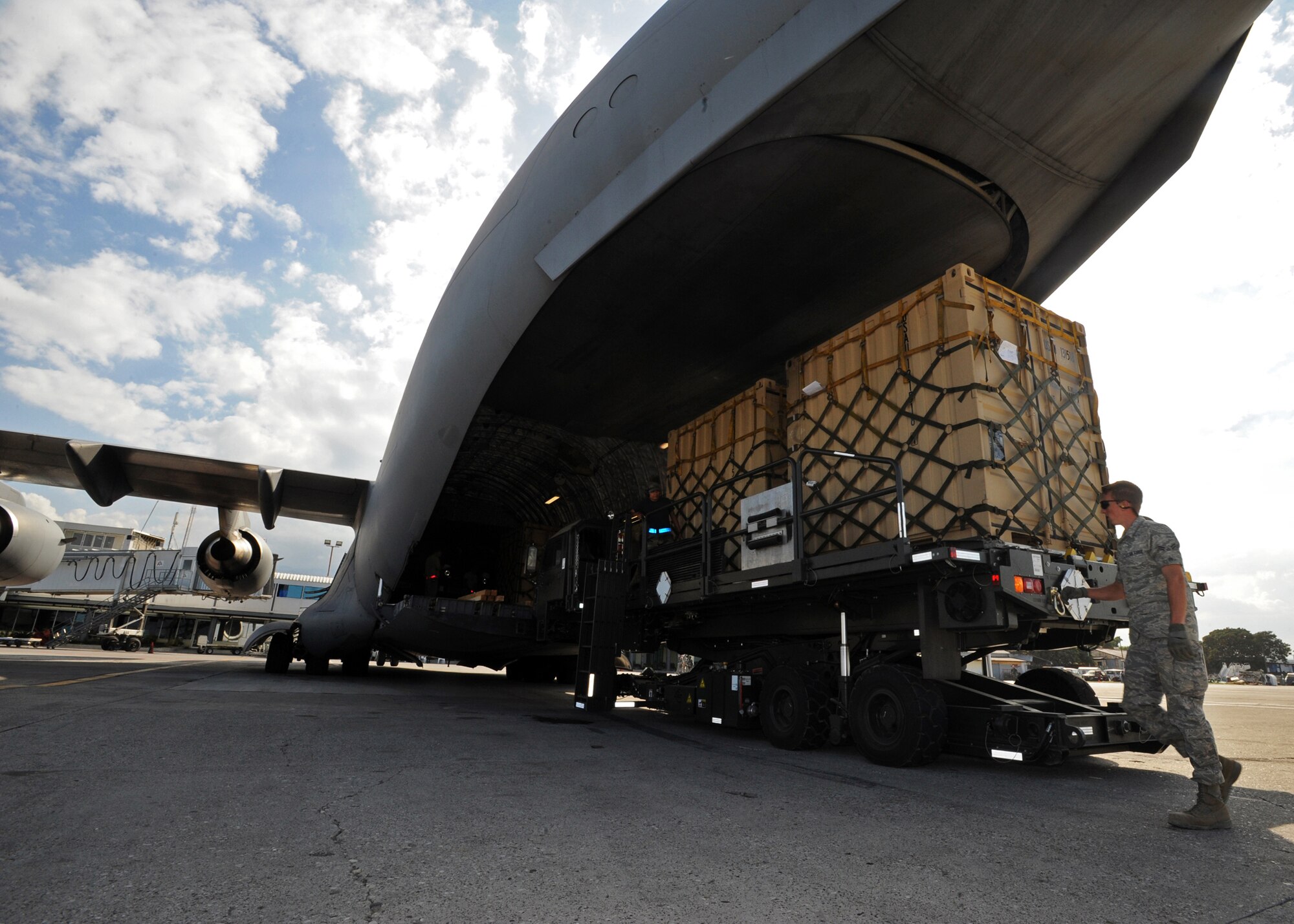 PORT-AU-PRINCE, Haiti -- Cargo Pallets are removed from a 517th Airlift Squadron C-17 Globemaster III at the Port-Au-Prince International Airport Jan. 31. The C-17 delivered Soldiers, a truck with water tank and pallets of gear to be used in the Haiti relief effort. (U.S. Air Force photo/Senior Airman Laura Turner)