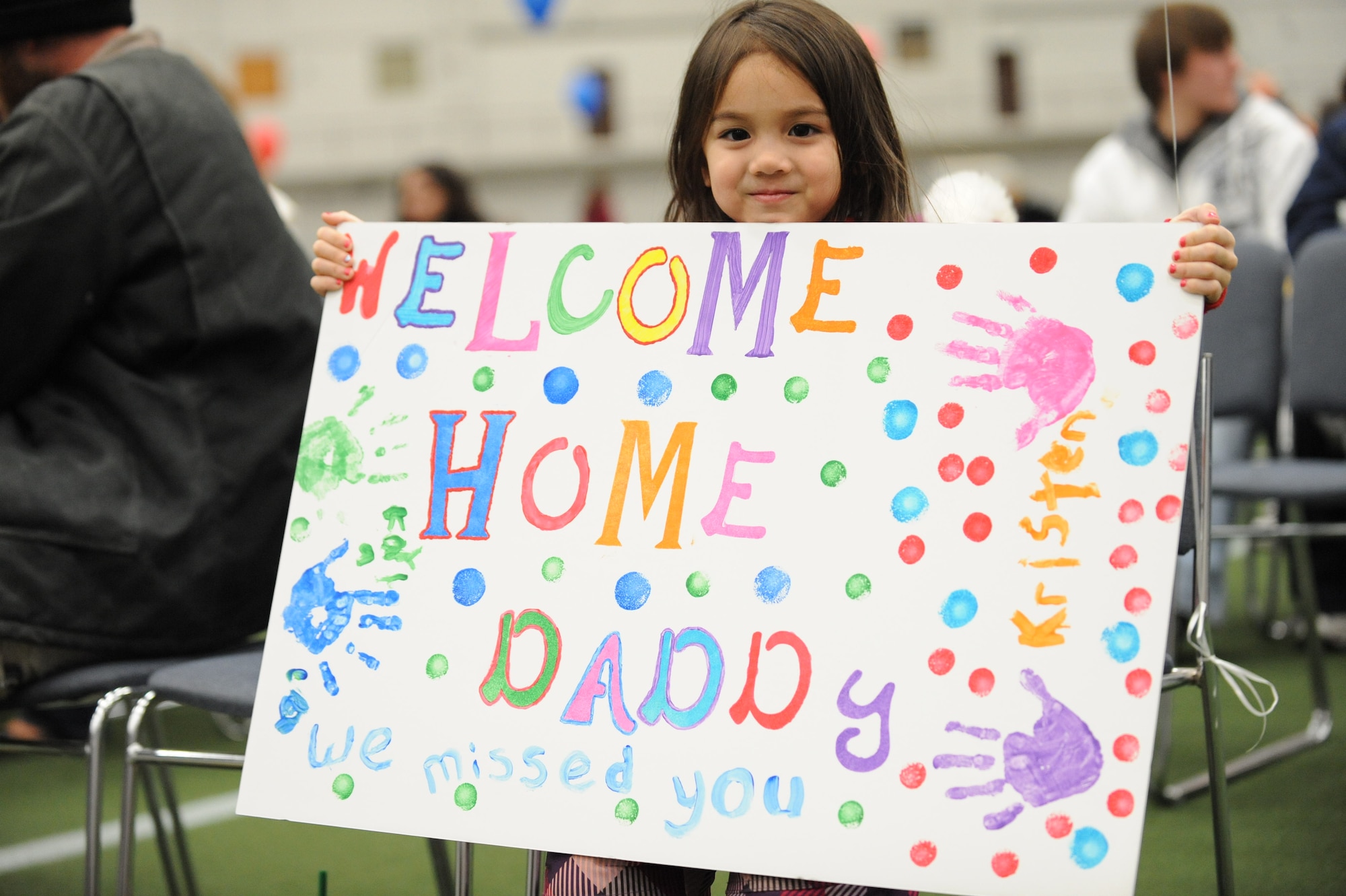 ELLSWORTH AIR FORCE BASE S.D.-- Kayla Maquindang holds a sign to greet her father, Staff Sgt. Gerald Maquindang, 28th Aircraft Maintenance Squadron instruments flight controls craftsman, upon his arrival from a deployment,  Jan. 29. While deployed to Southwest Asia, Sergeant Maquindang provided support to Operations Iraqi and Enduring Freedom. (U.S. Air Force photo/Airman 1st Class Corey Hook)